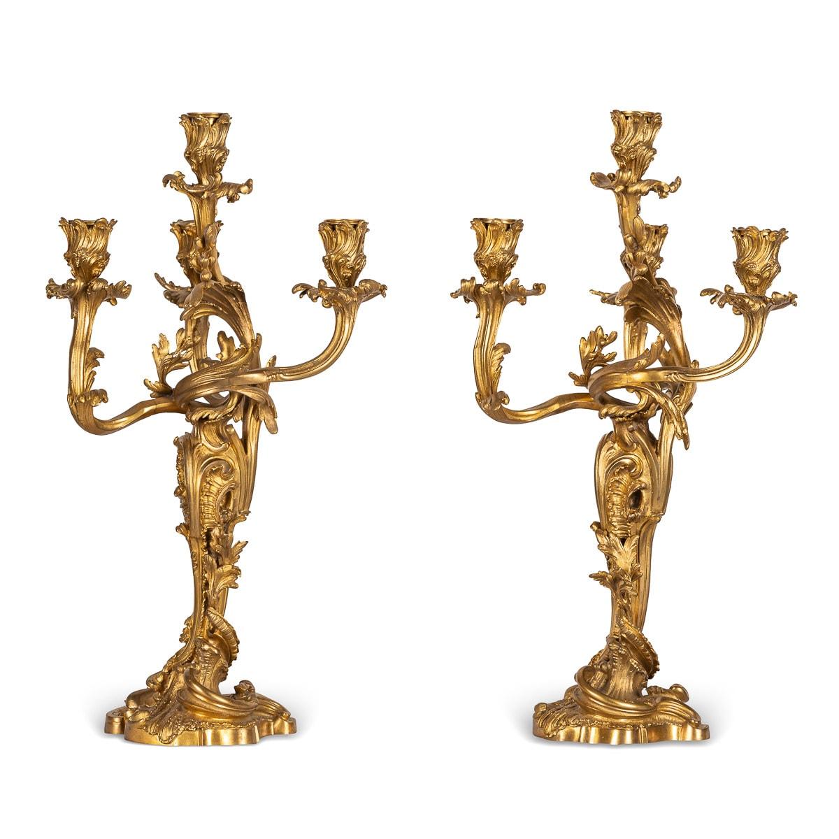 Antique late-19th century French pair of Louis XV style ormolu bronze four-light candelabra, beautifully modelled in the Rococo style, each foliate-sheathed spirally fluted baluster stem supporting candlearms, decorated with acanthus-leaf and flower