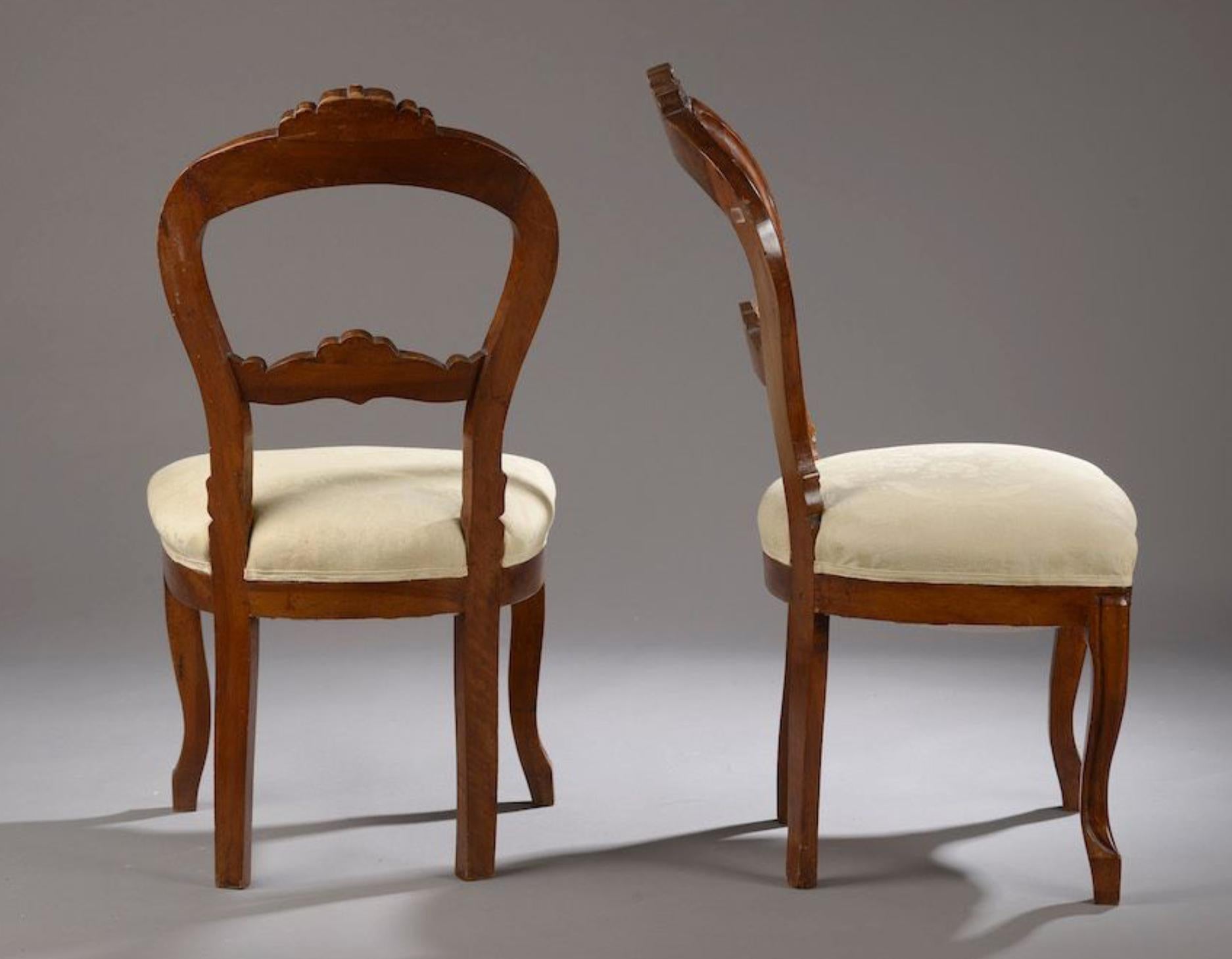 paire de chaises du XIXe siècle en acajou et placage d'acajou en bois mouluré et sculpté, le dossier et la ceinture centrés d'un écusson sur fond de draperies. Ils sont basés sur des pieds avant sinueux.

France XIXe siècle.

Haut. : 91 cm -