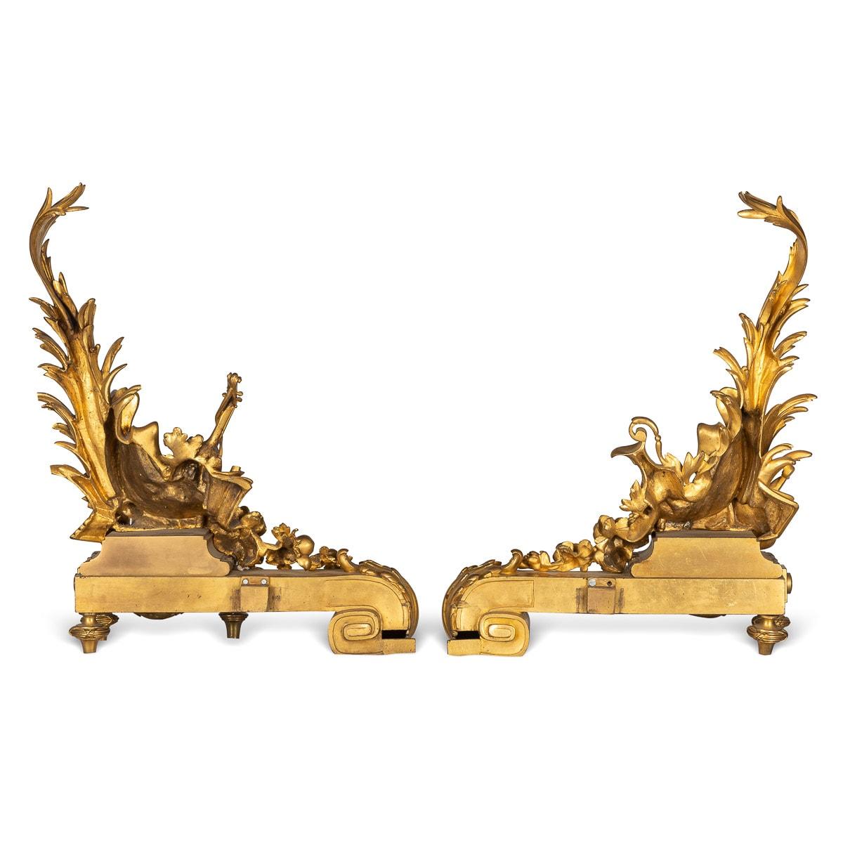 Antique 19th Century French beautifully cast pair of gilt bronze fireplace chenets. These chenets are adorned in themes of leisure, music, art and wine amongst beautiful floral scrolls, garlands and swags.

CONDITION
In Great Condition, wear