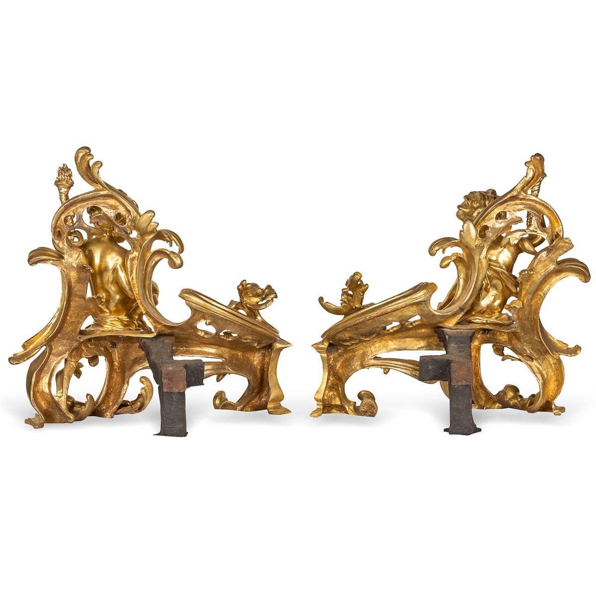 Antique 19th century French exceptionally made cast pair of gilt bronze fireplace chenets. These chenets are adorned by reclining puttis holding a torch on beautiful rococo scrolling foliage.

CONDITION
In Great Condition - No