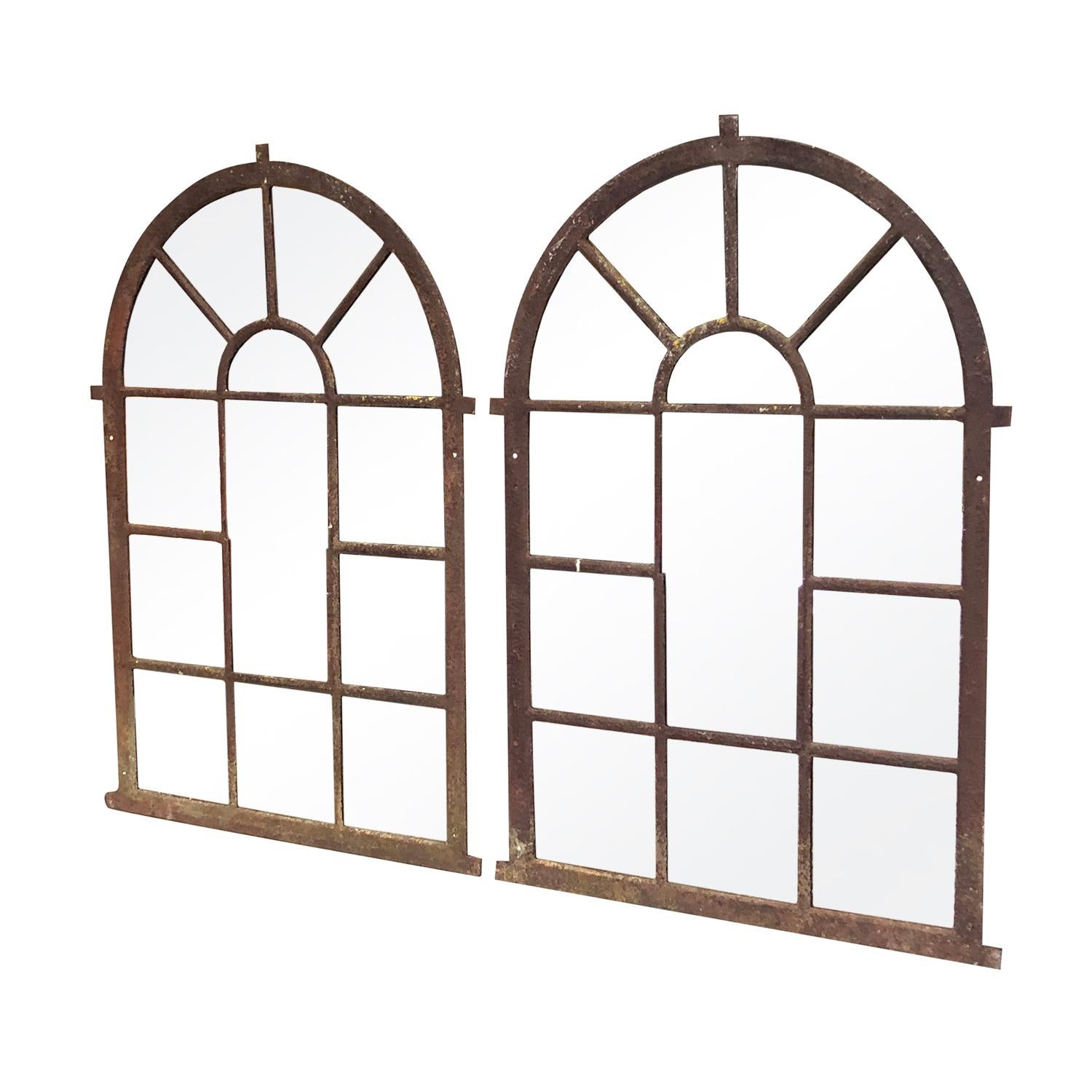 A pair of antique French Orangerie mirror with an arched top, in good condition. These wall mount structures have cast iron antique frames and newly inserted mirrored panels. The antique wall décor represents the Rococo time period. Wear consistent