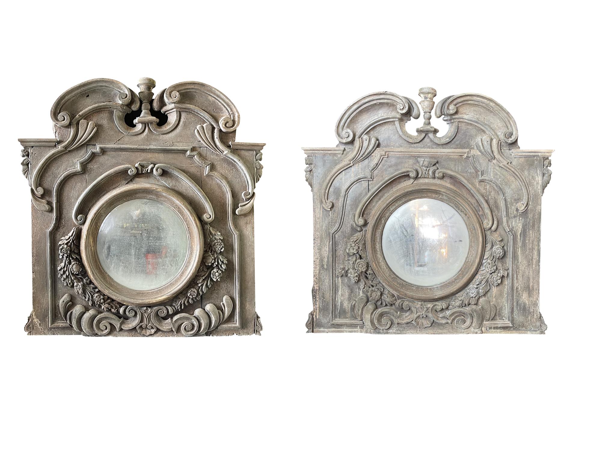 Ensemble de deux très grands miroirs muraux anciens avec d'opulentes sculptures en bois de noyer Boisserie avec des miroirs travaillés, en bon état. Le verre miroir est d'origine. Ces ornements muraux de style baroque présentent des sculptures