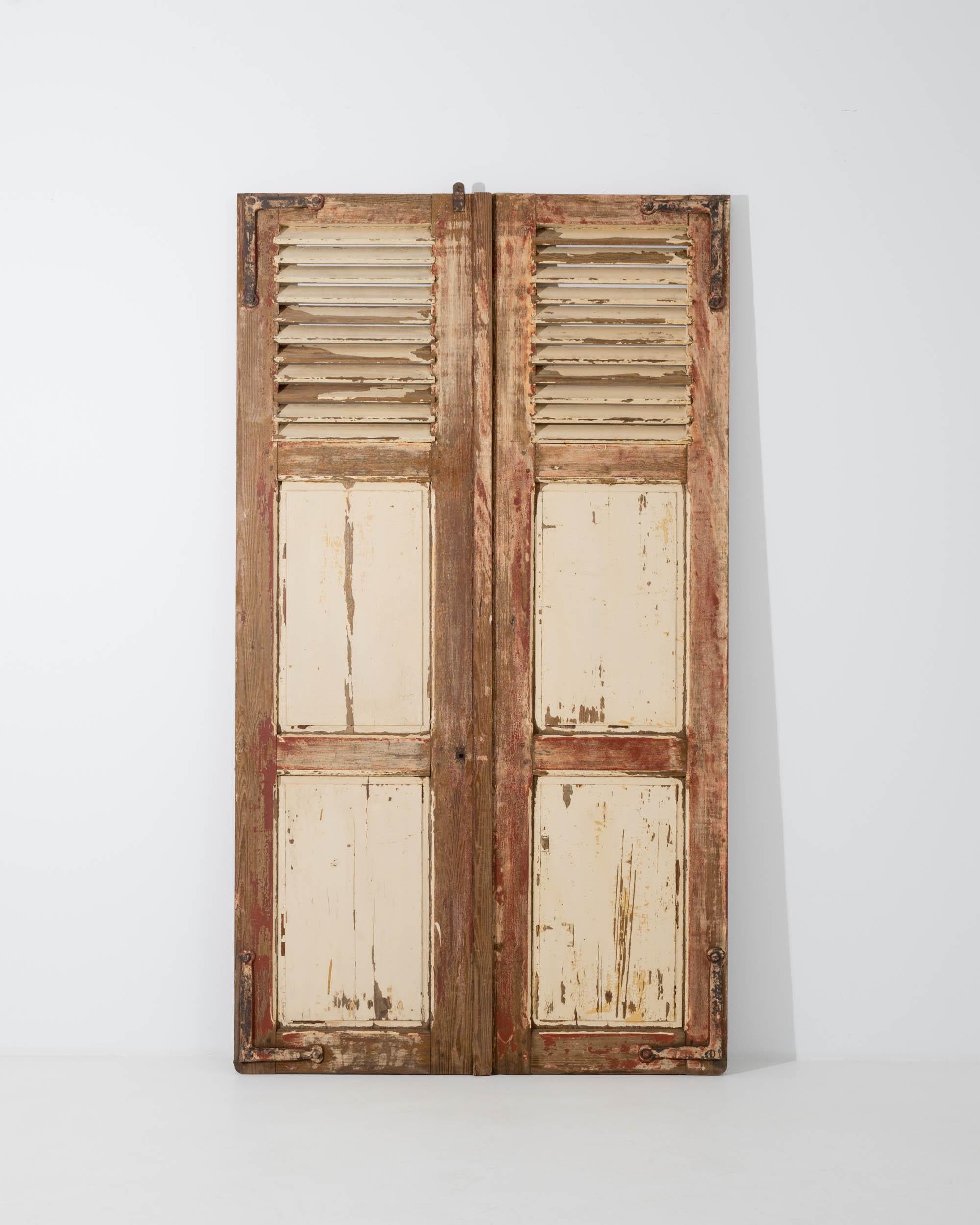 This enchanting pair of antique wooden shutters evokes the romance of a provincial chateau. Made in France in the 1800s, these pieces would have originally served to cover the windows at night-time or during the heat of the summer afternoons. Angled
