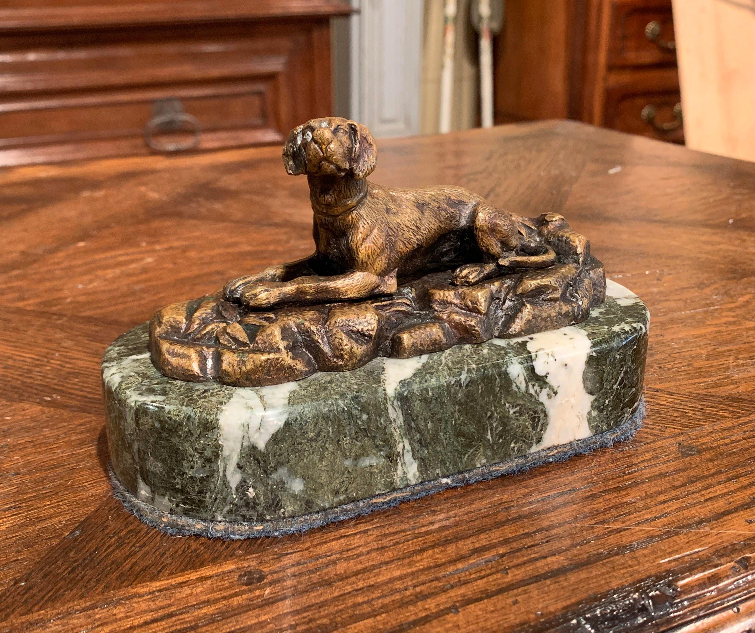 Questo antico cane scultura fermacarte è stato creato in Francia, intorno al 1880. Posta su una base ovale in marmo grigio e bianco con feltro inferiore, la scultura raffigura un cane da caccia che riposa su un terreno roccioso alla maniera di