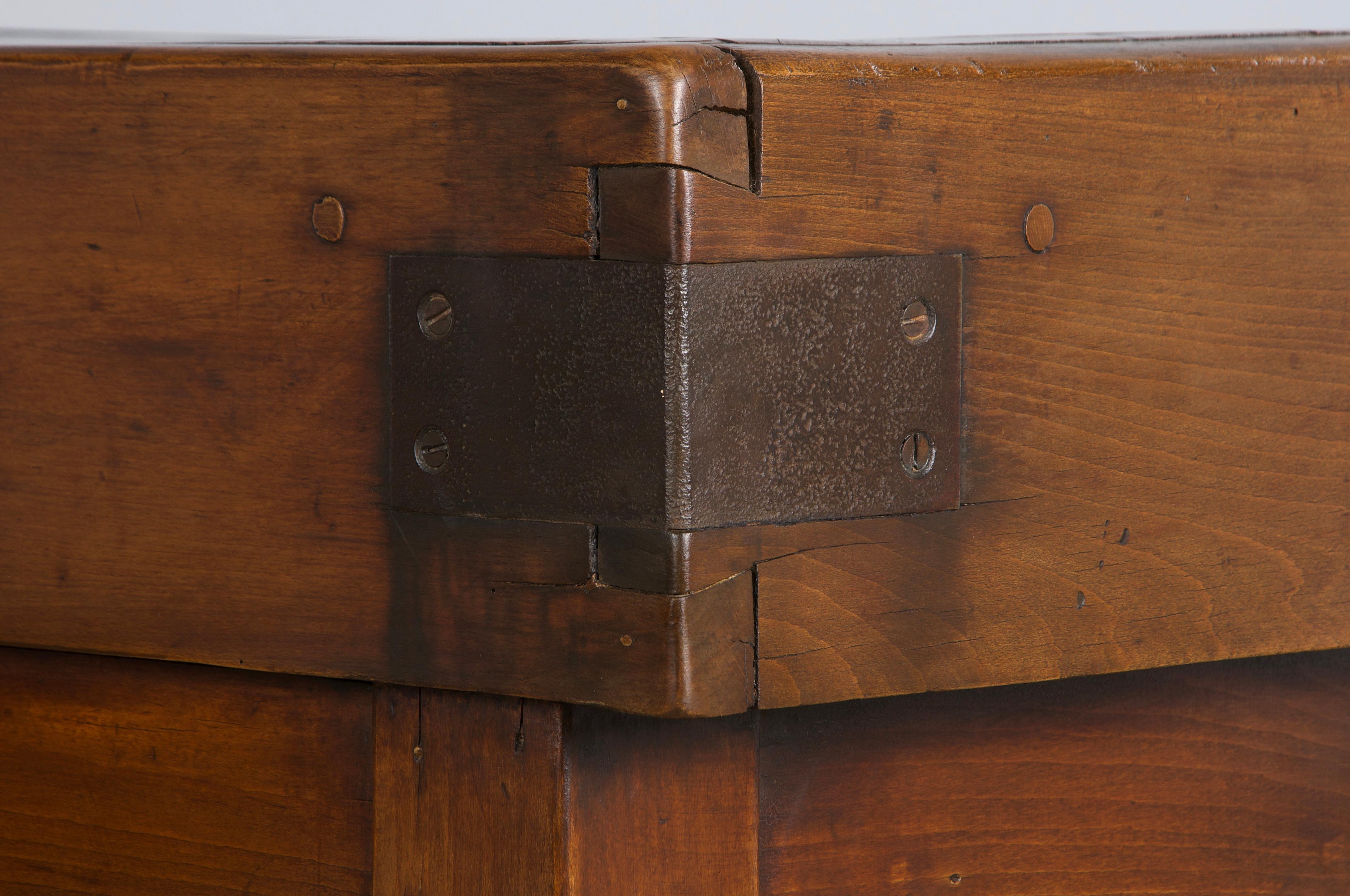 A striking late 19th-century traditional French butcher block table or island from Paris, France. Expertly handcrafted from solid maple, it features a rectangular parquetry top with a narrow profile. The front is fitted with a central storage
