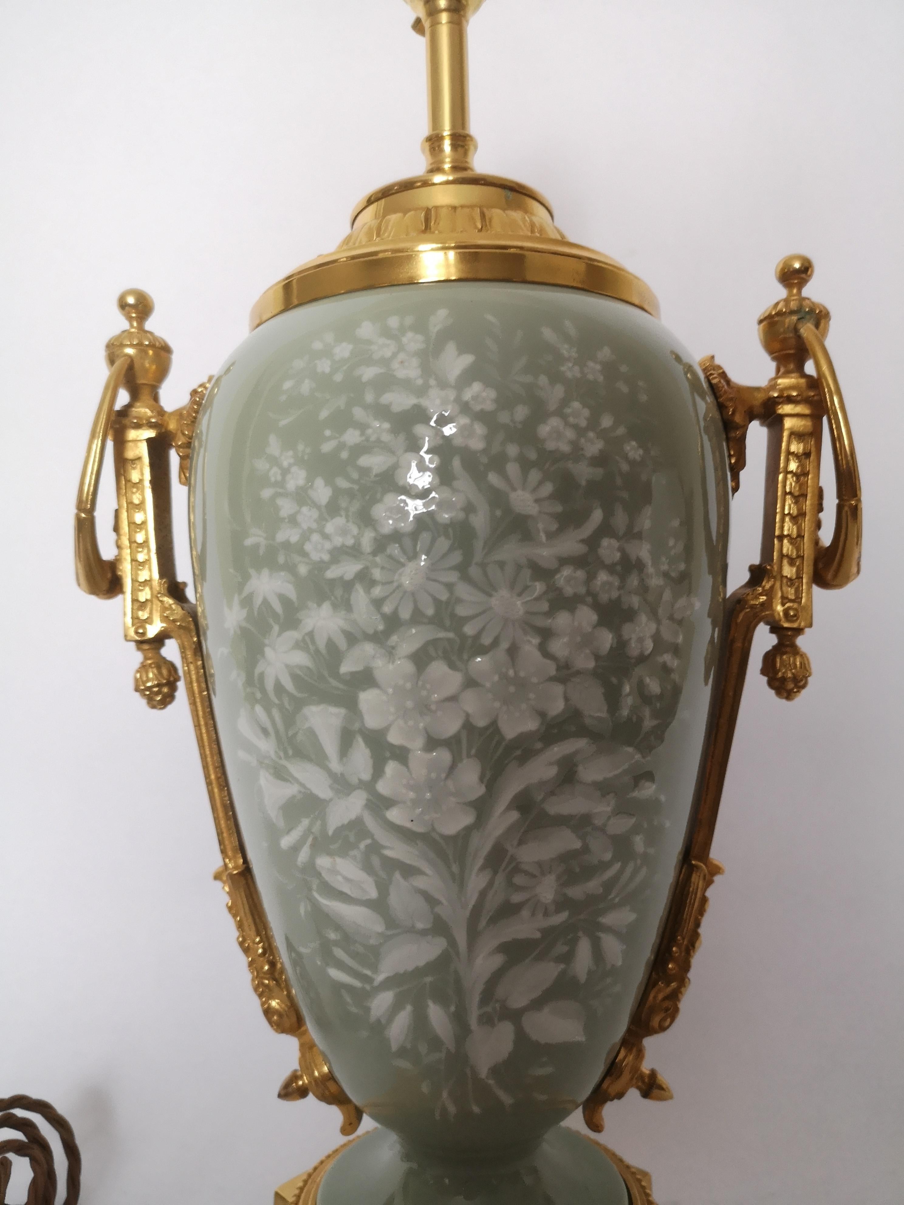 A very decorative 19th century French lamp, the celadon coloured porcelain body decorated in white Pate Sur Pate floral decoration. Gilded bronze mounts with ring handles and standing on a four footed gilt bronze base.
Wired for the UK.
French,