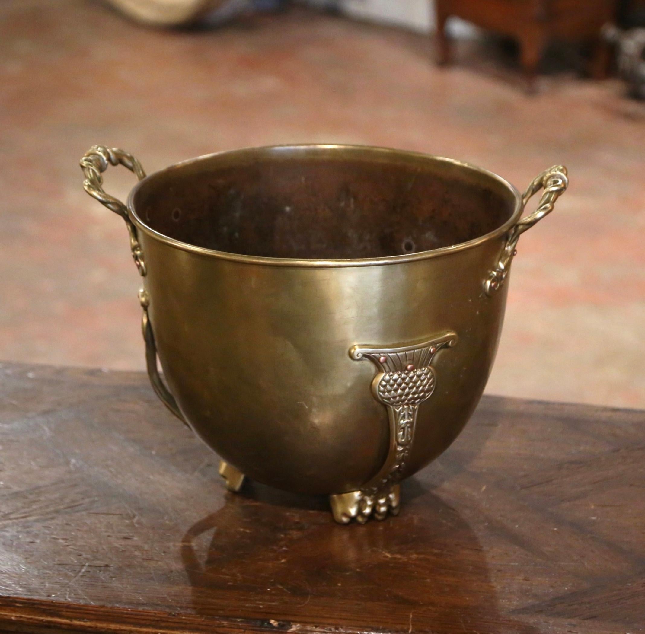 Bring an authentic French countryside touch to your kitchen with this large antique cache pot. Crafted in Normandy, France circa 1870, and round in shape, the bucket stands on small paw feet and is dressed with intricate side handles handle attached
