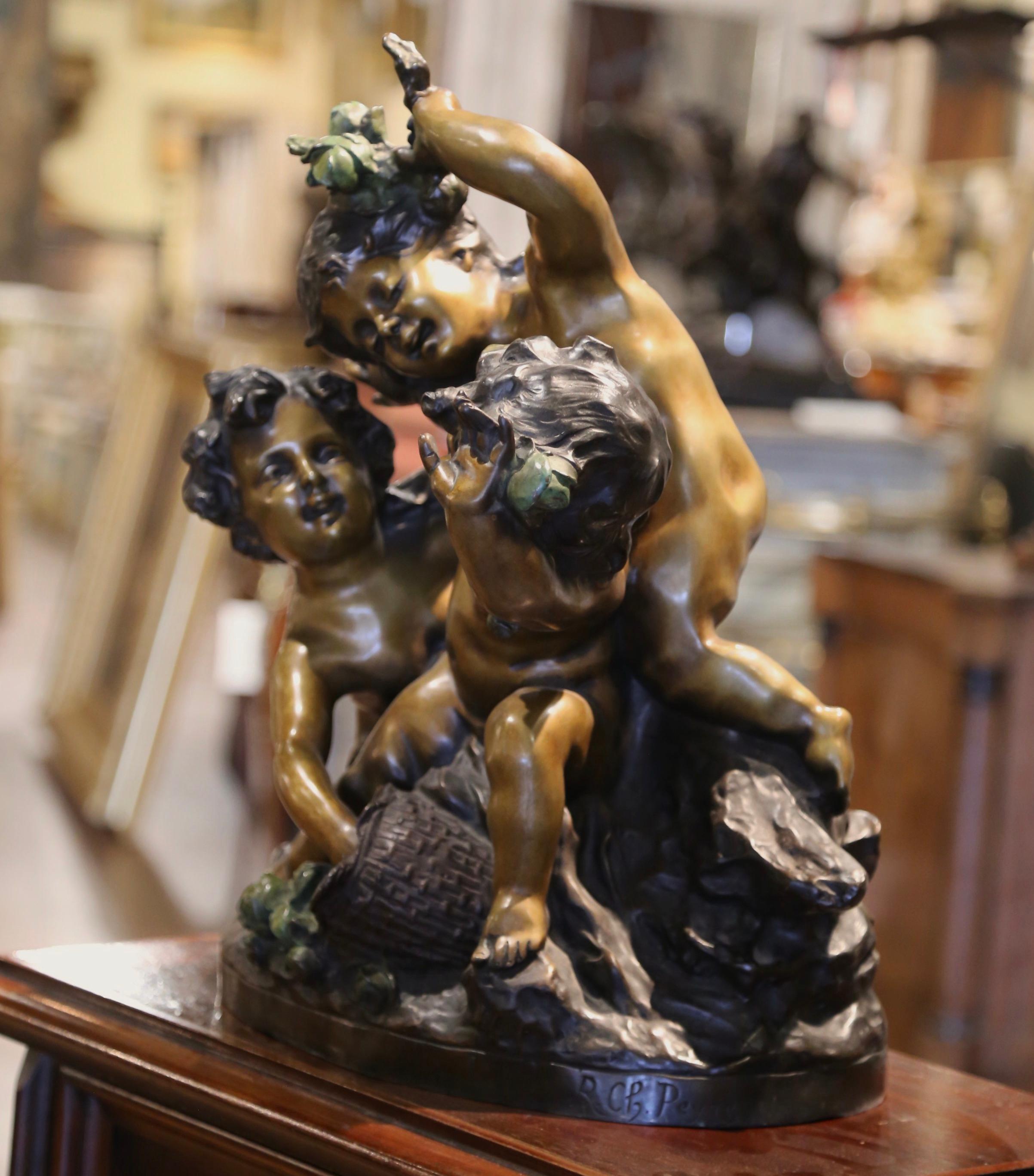 Arreda un ufficio o uno studio con questa elegante composizione in bronzo antico di bambini che giocano con i fiori. Realizzata in Francia intorno al 1895 e costruita in bronzo, l'allegra composizione raffigura tre putti giocherelloni, uno che