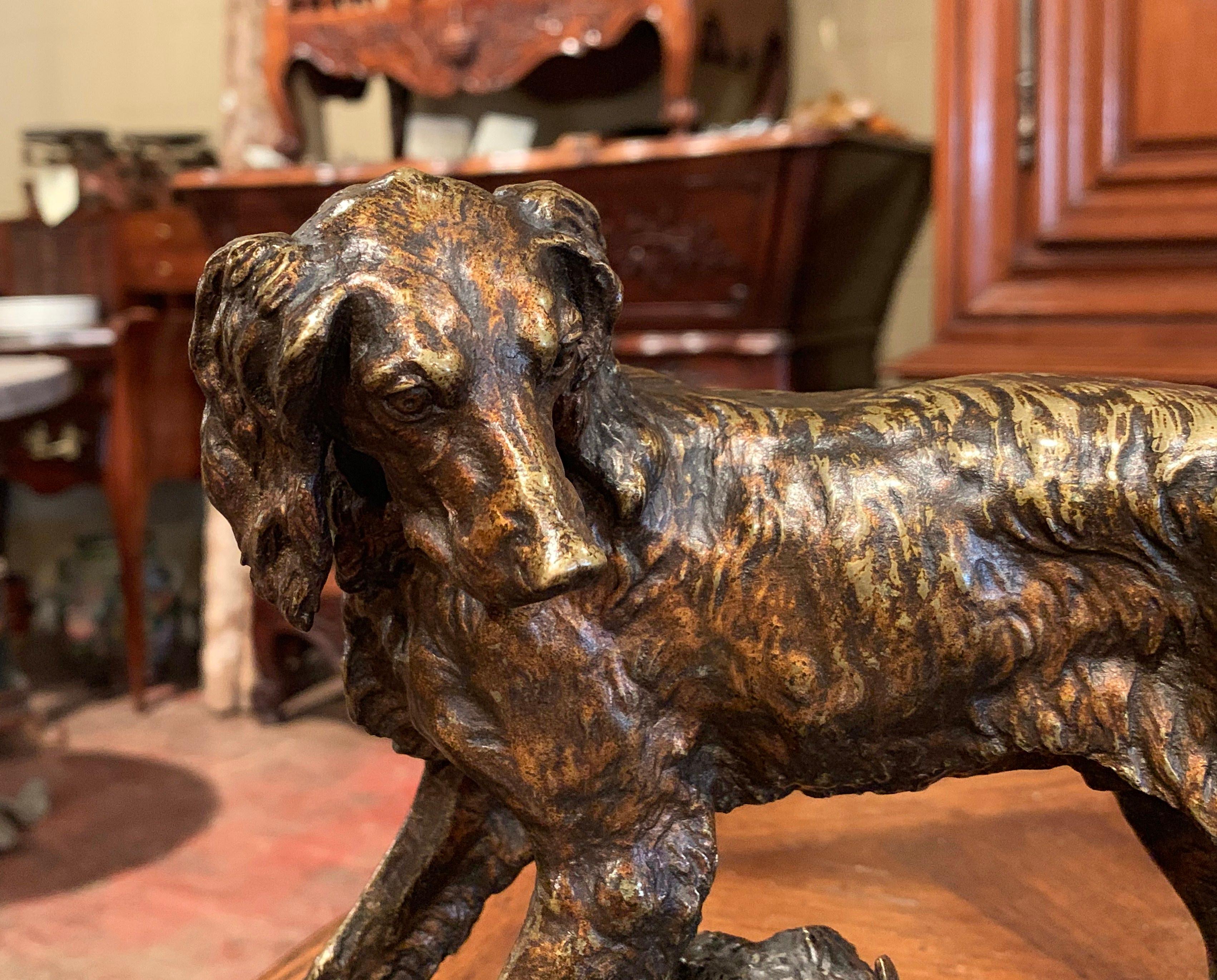 This antique bronze sculpture was created in France, circa 1870. The composition features a setter standing on rocky ground with leaf and branch decor and looking to the side. The hunting dog figure is signed on the front, Jules Moigniez. The