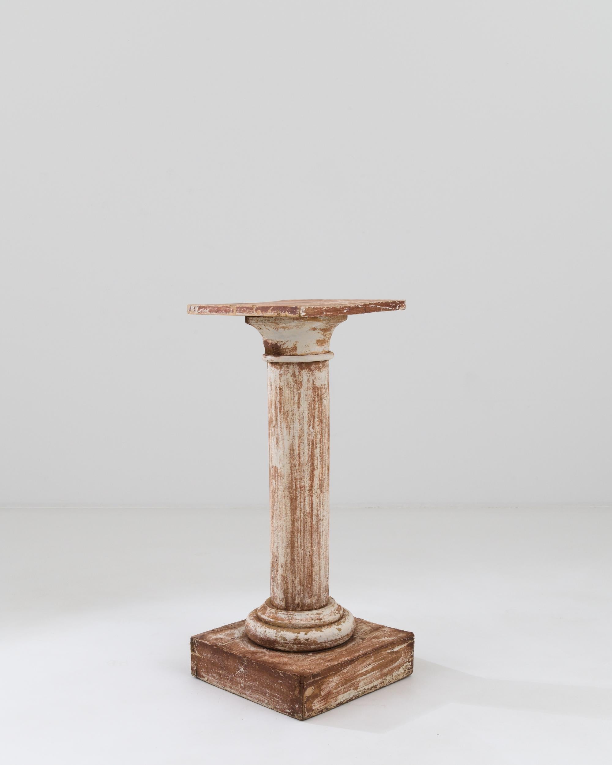 A wooden pedestal created in 19th century France. Presenting itself with a stoic poise, this simple yet elegant pedestal exudes charm and a sense of history. The white paint that coats the surface of the pedestal has long since begun to wear away