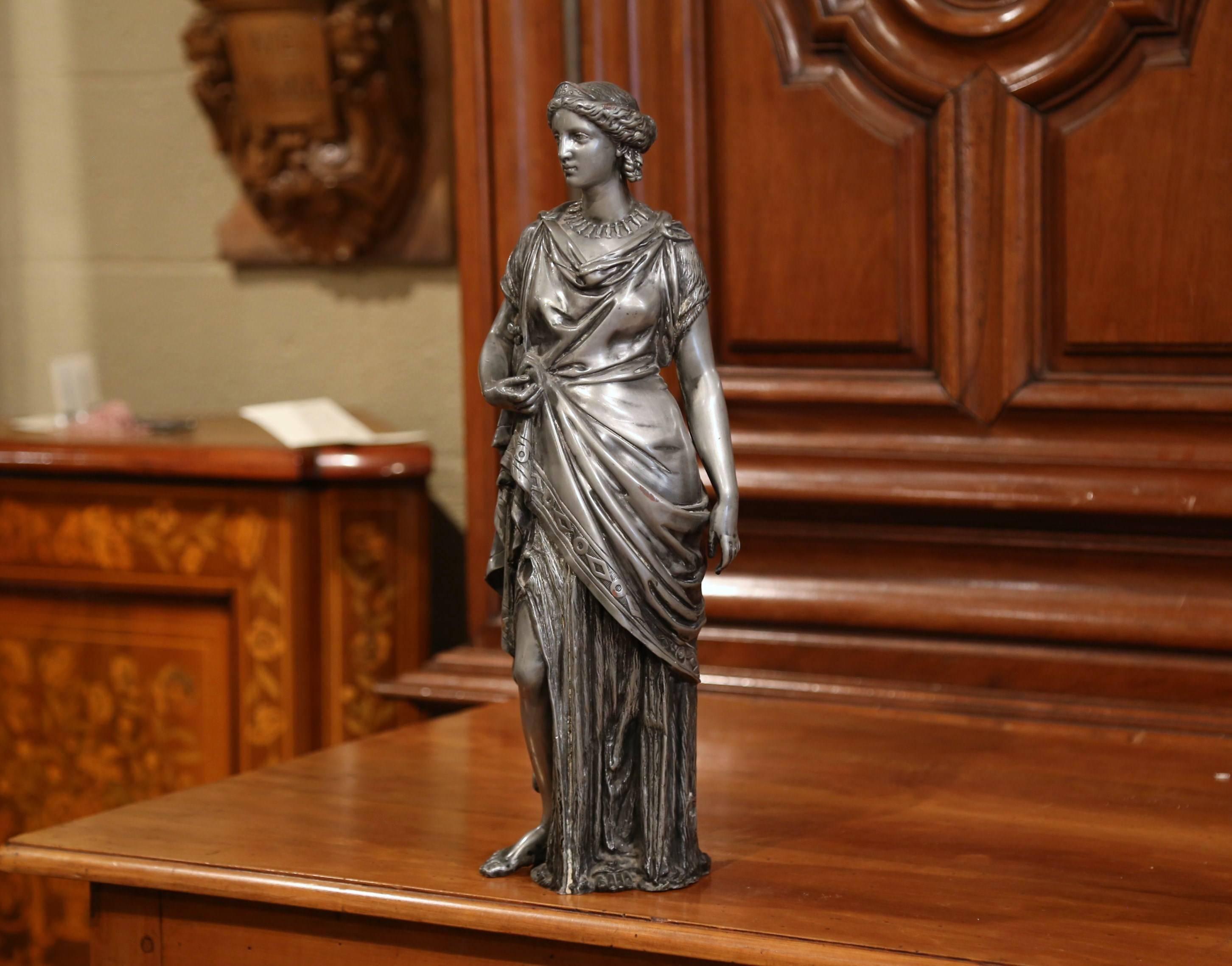 This elegant and detailed antique statue was sculpted in France, circa 1870. The beautiful, traditional figure made of pewter, features a Roman goddess figure dressed in elaborate clothing and jewelry. The figurative sculpture is in excellent