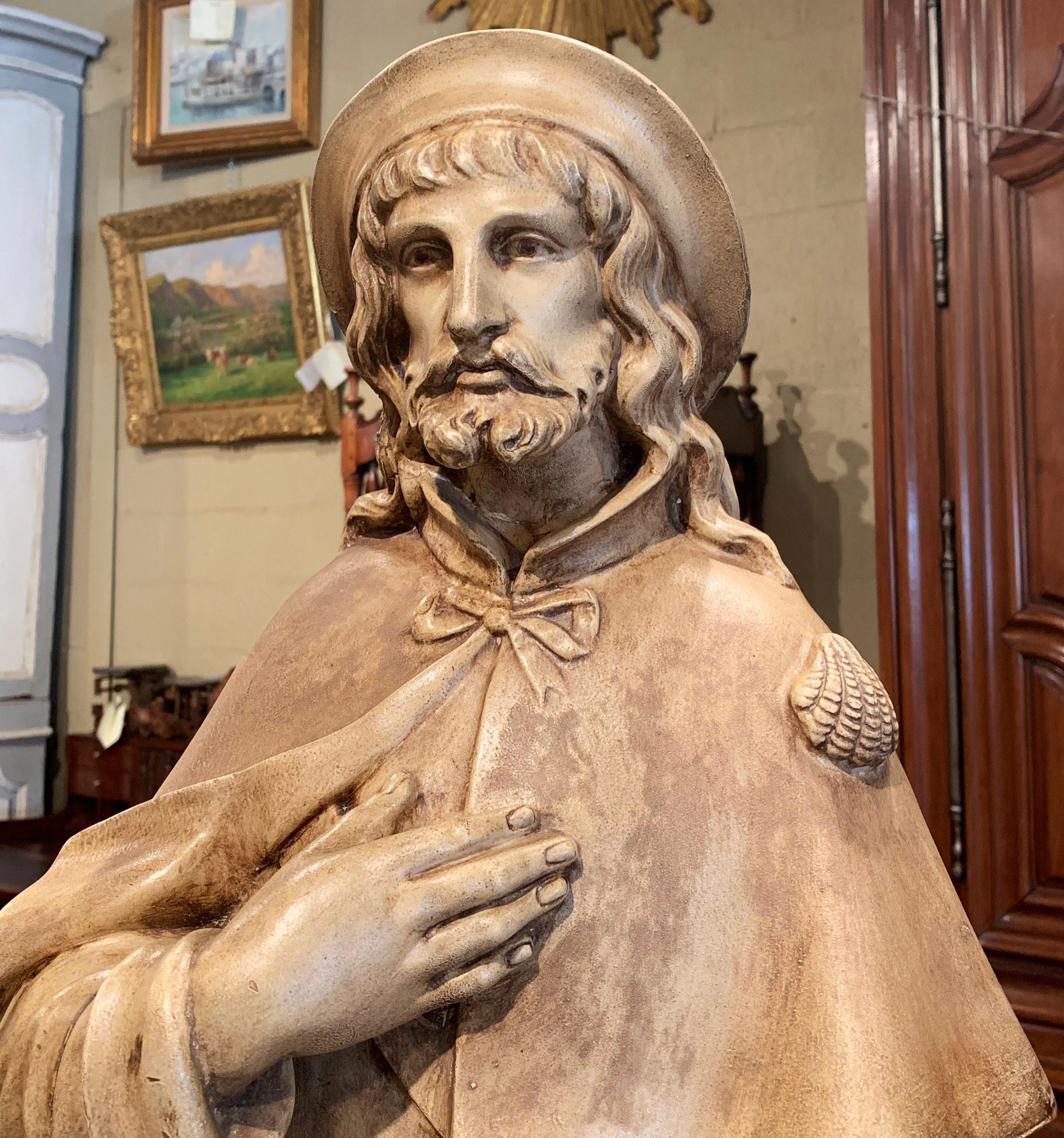 This fine terracotta sculpture was crafted in France, circa 1870. The tall statue depicts Saint Roch or Rocco, a Catholic man who was saved by a dog after he contracted the Plague. The sculpture is in very good condition with exquisite details and a