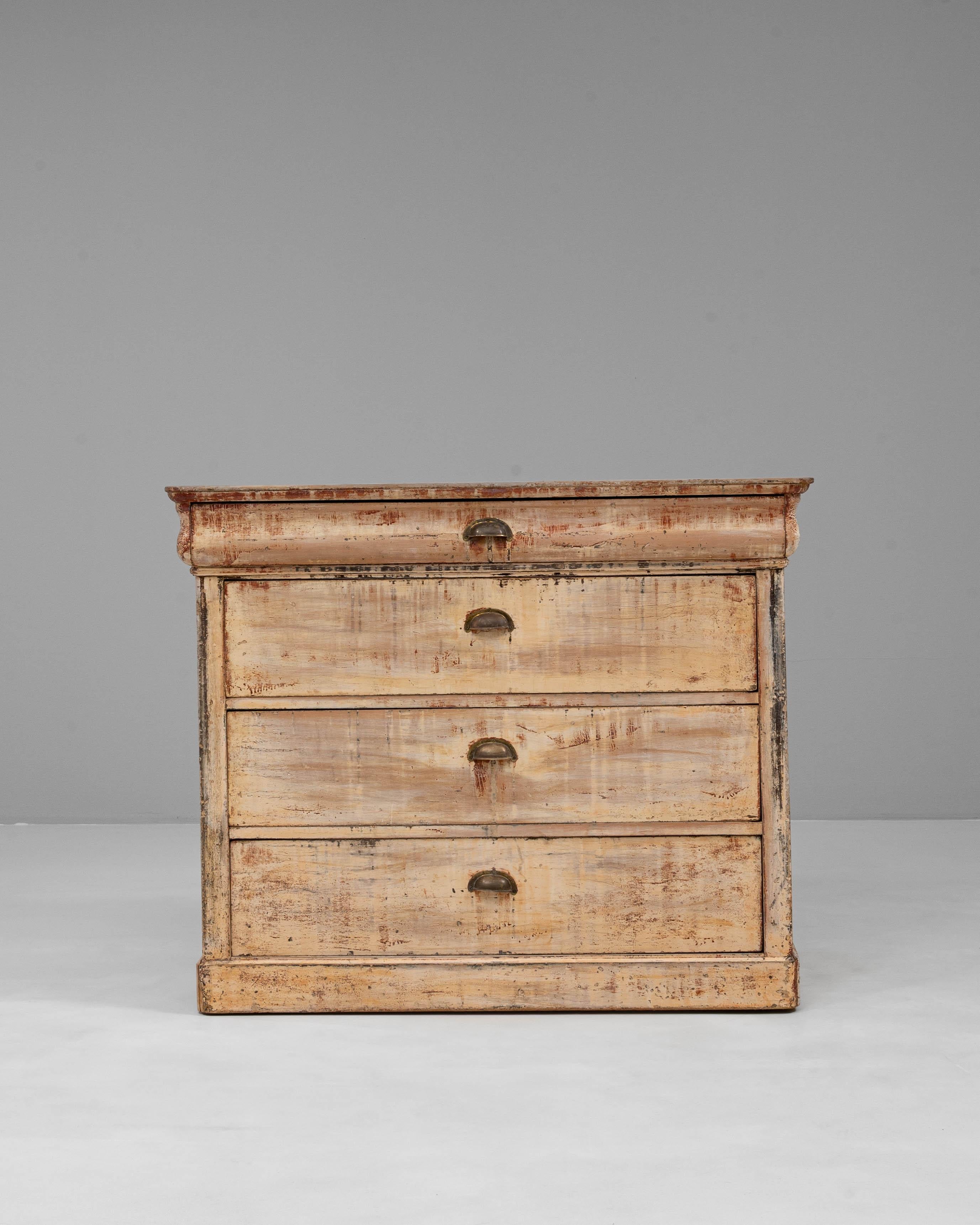 Cette commode en bois patiné français du XIXe siècle est un bel exemple de design provincial rustique, mettant en valeur à la fois la fonction et le caractère. Fabriquée en bois massif, la commode comporte quatre tiroirs spacieux dotés de simples