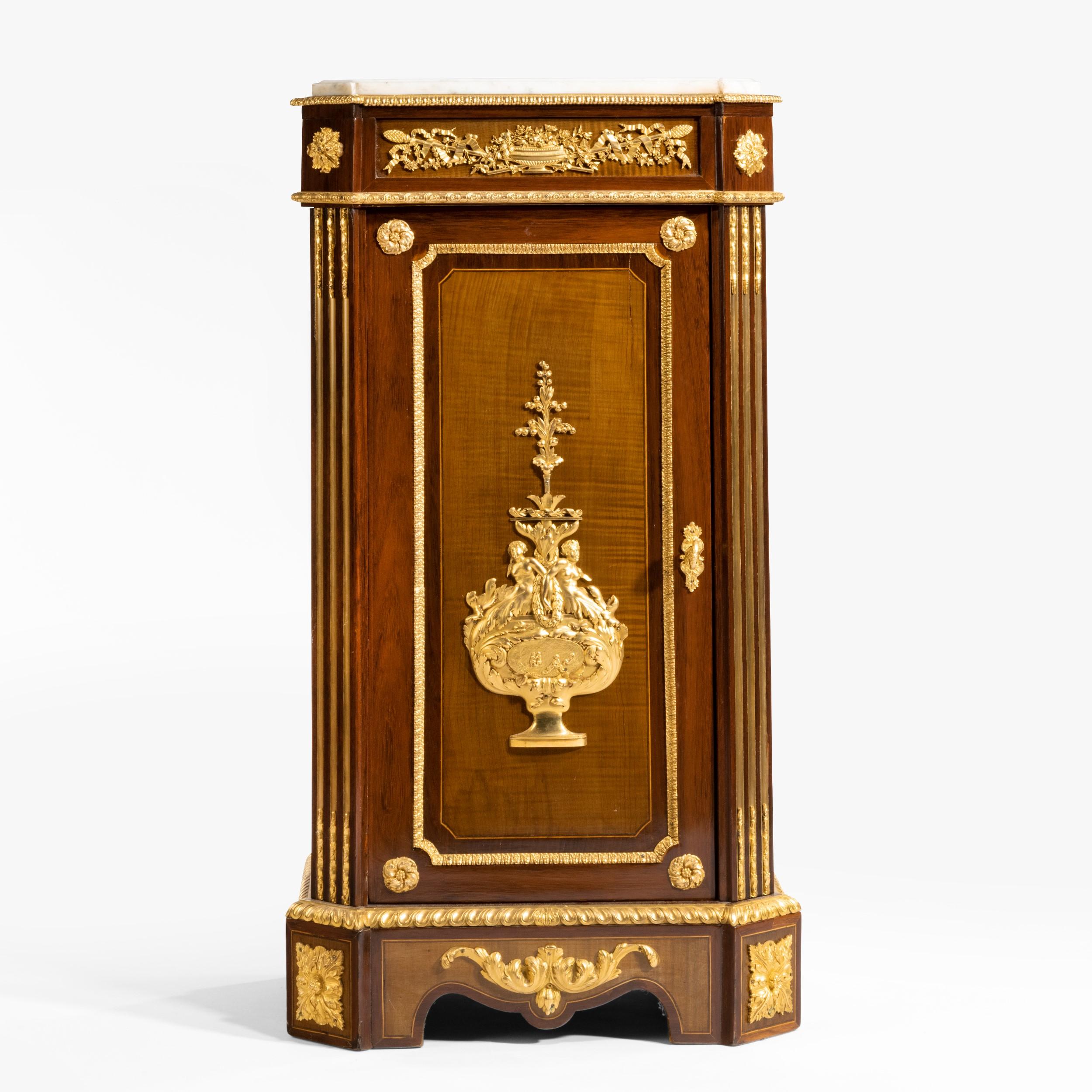 A splendid side cabinet
By Mathieu Befort, dit Befort Jeune of Paris

Constructed in amaranth, with gilt bronze mounts, rising from bracket feet, the cabinet having a lockable door dressed with a central gilt bronze mount within a stiff lead