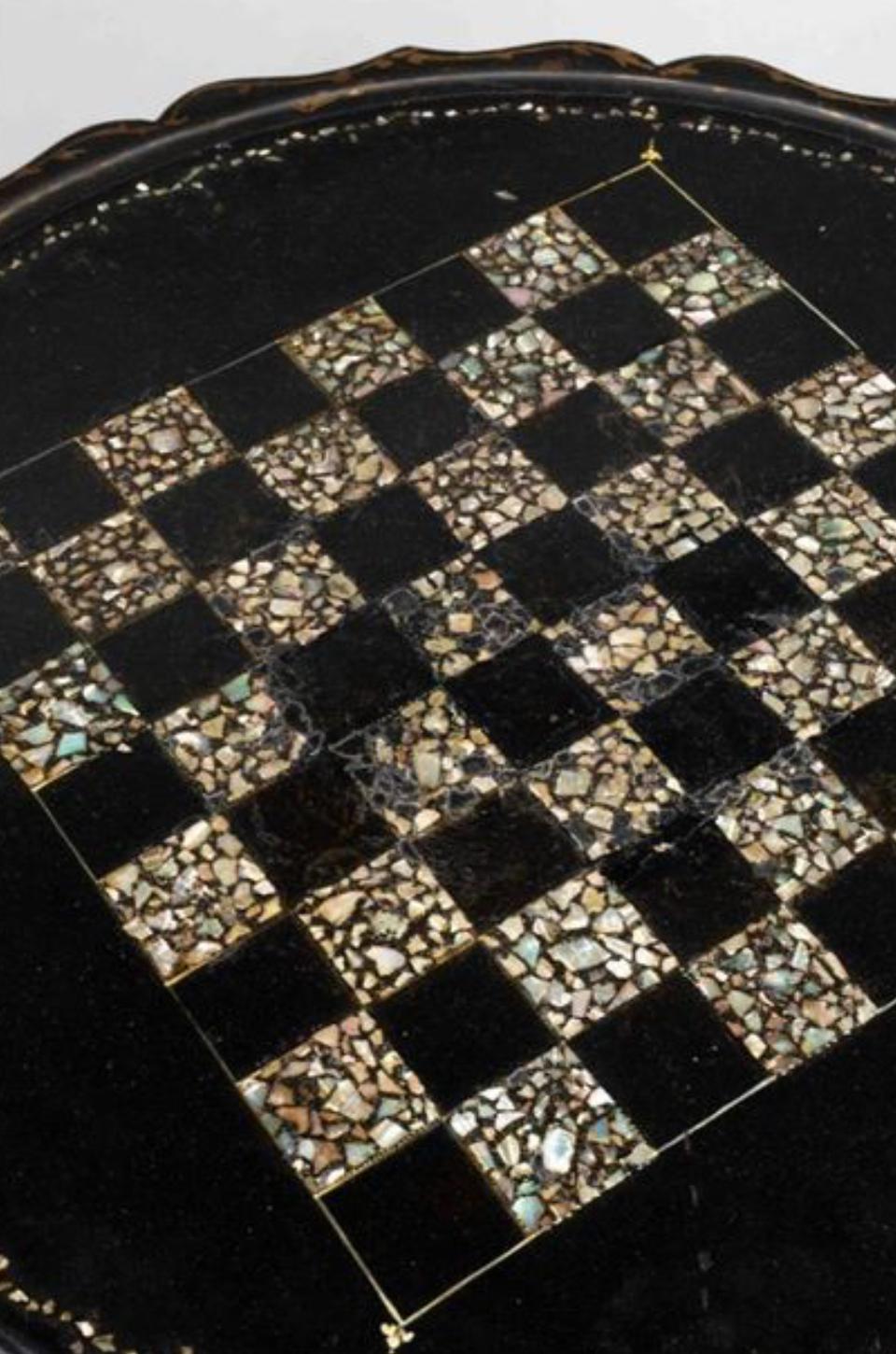 Mesa con pedestal del siglo XIX en cartón piedra ennegrecido y realzado con dorado. Bandeja de nácar a cuadros que descansa sobre un marco central torneado y se apoya en una base de tres patas del periodo de Napoleón III.
Medidas: A. 74 cm, P. 61