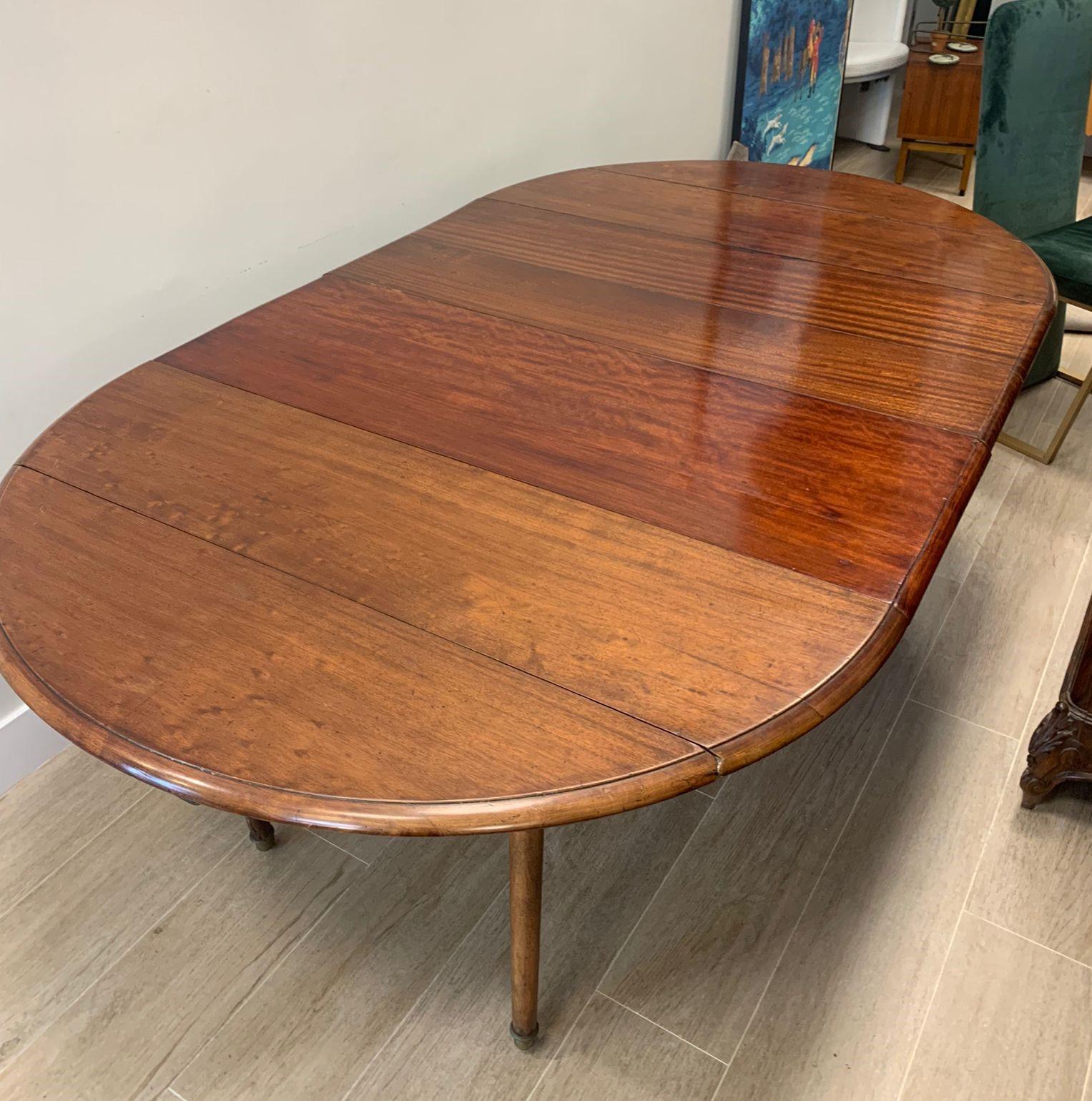 Amazing Dining table made with mahogany wood. This pembroke table is made up of a rectangular top, two semicircular wings that extend through sliding wooden slats, and six legs with wheels that make it easy to move.

The Pembroke table has its