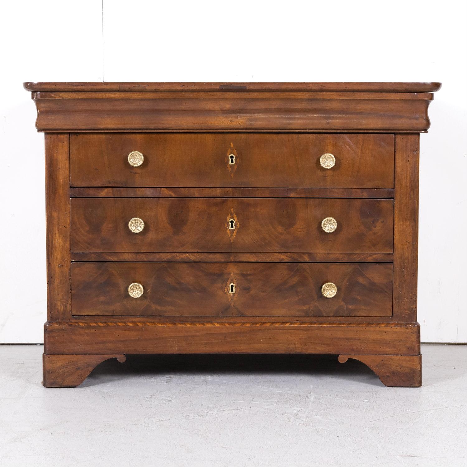 An exceptional 19th century French Louis Philippe period commode, circa 1840s, handcrafted in Lyon of walnut and fruitwood parquetry with a bookmatched front. This fine chest of drawers features a hidden doucine top drawer and three drawers below,