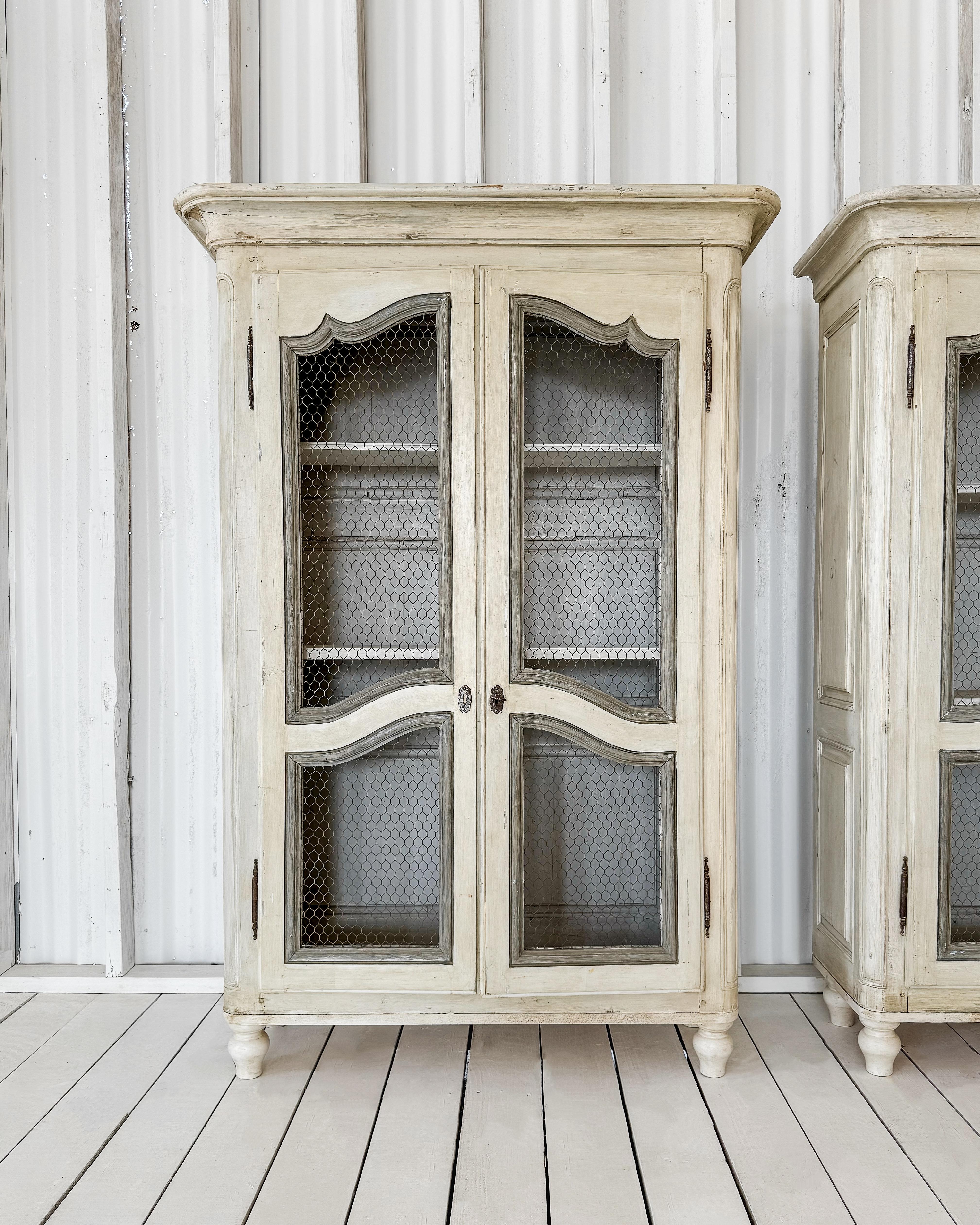 Un'antica libreria provinciale francese che rappresenta uno straordinario esempio di artigianato. Il mobile in legno massiccio presenta un design splendidamente intagliato con pannelli laterali dettagliati in rilievo. Le due ante a pannelli sono