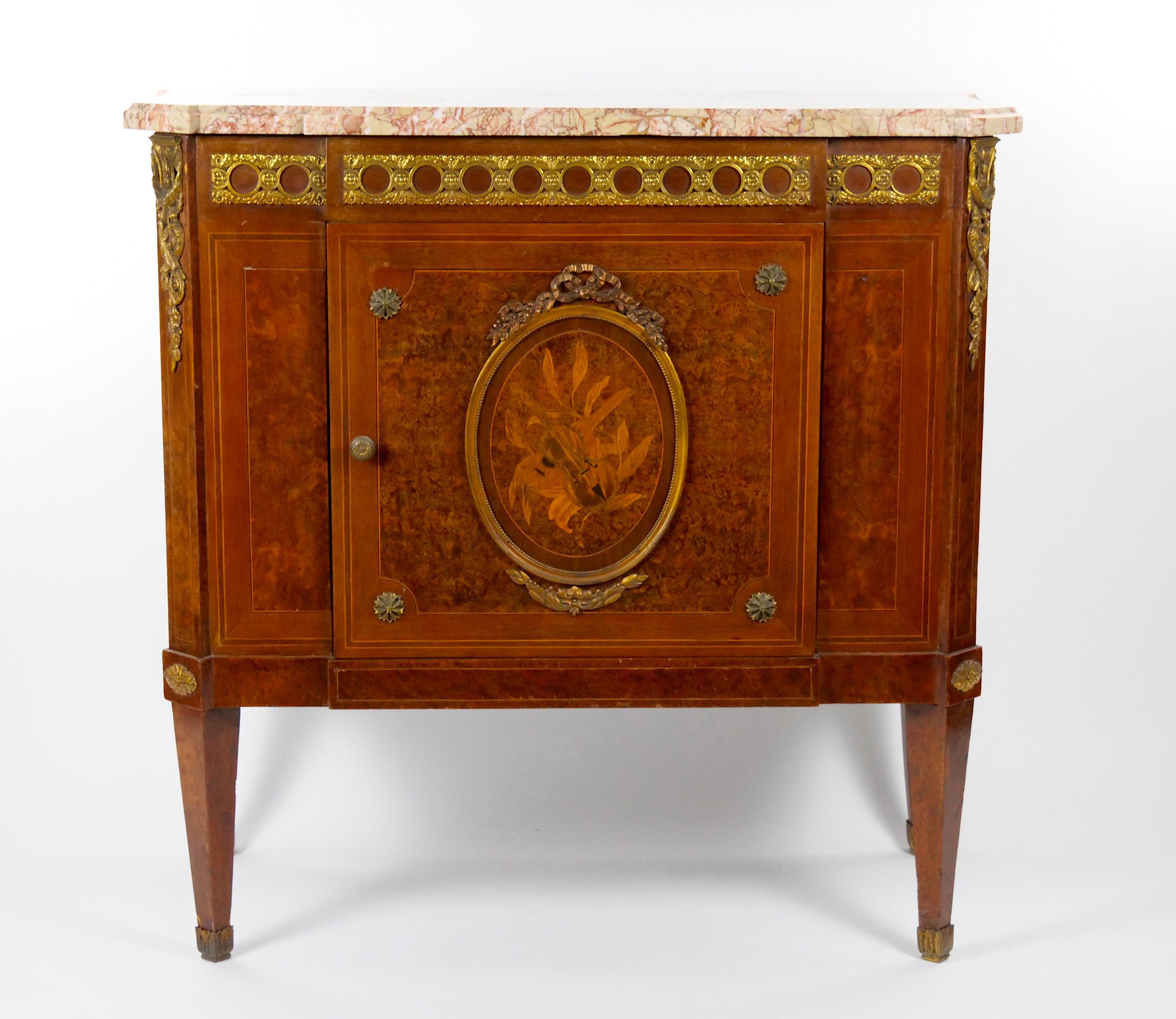 
Step into a realm of unrivaled grandeur with this extraordinary 19th century French petite commode sideboard cabinet, masterfully crafted in the esteemed Louis XVI style. Every detail of this opulent piece speaks volumes about the impeccable
