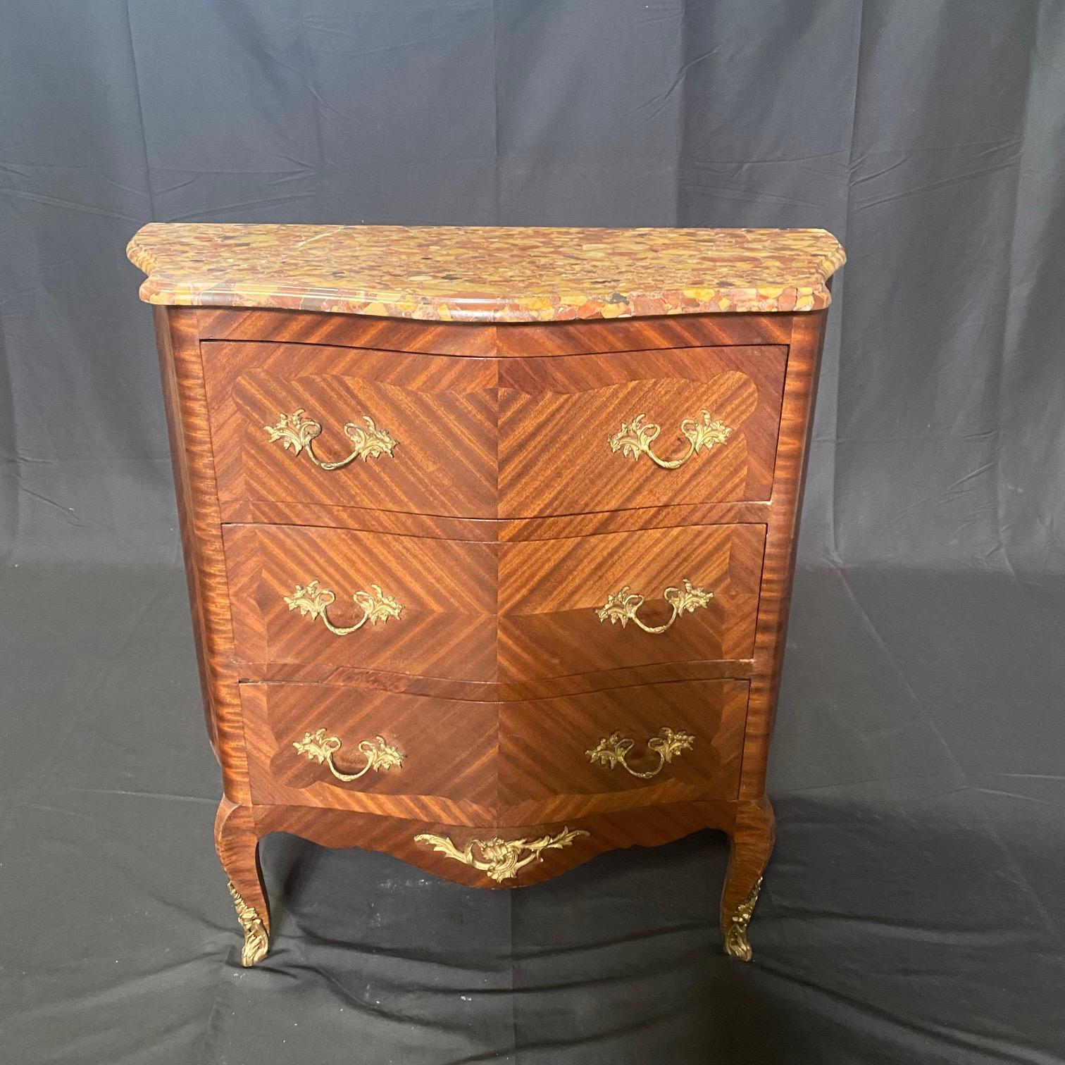 Exquisite French Louis XV marble top commode is a true statement piece that will elevate any room in your home. The chest of drawers features elegant gold trim that adds a touch of luxury and sophistication, and the marble top not only enhances the