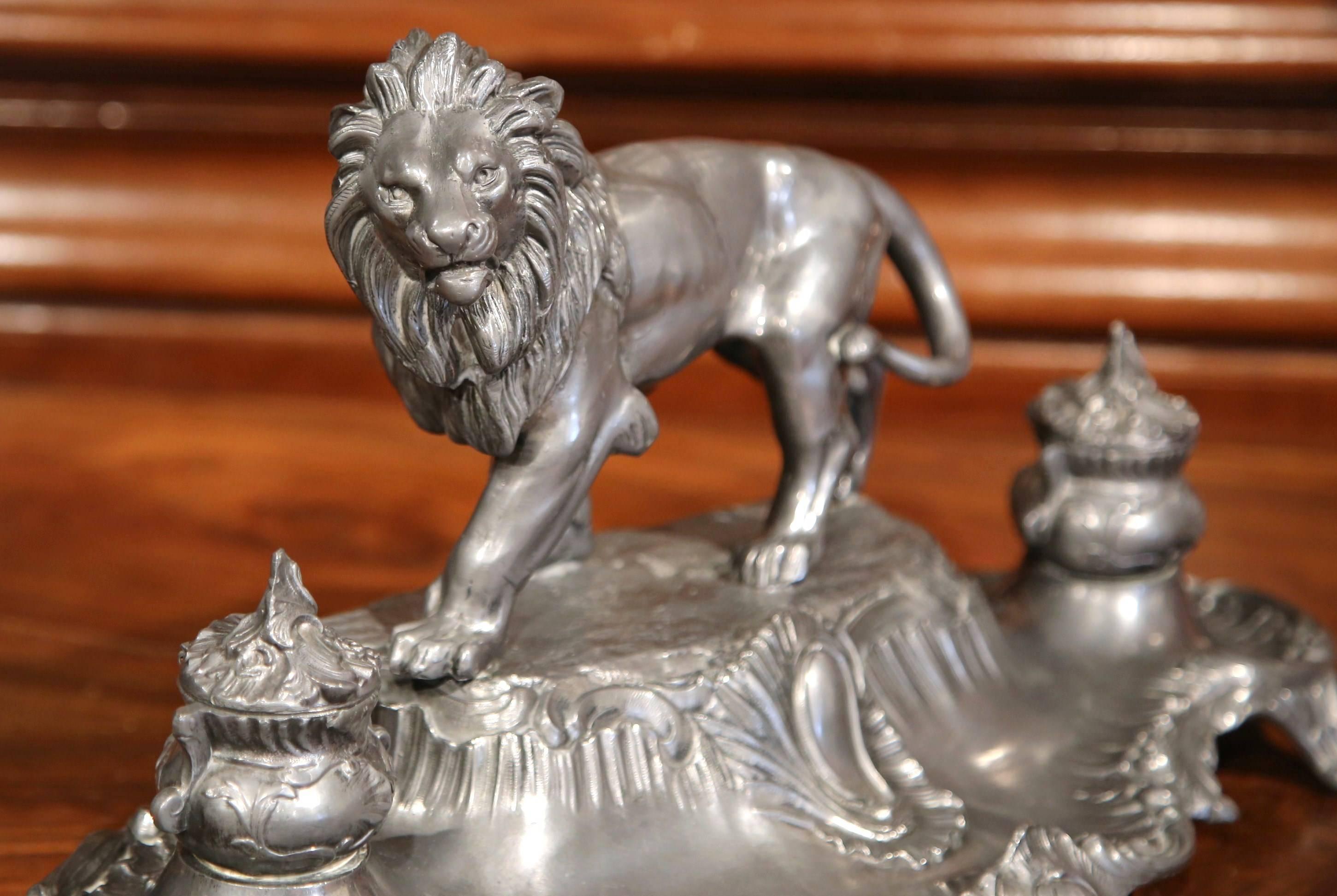 Place this elegant antique signed inkwell in a man’s office. Created in France, circa 1880, the pewter desk accessory sits on four small curved feet, and features a proud lion figure standing on a mount flanked with two round ink holders and lids,