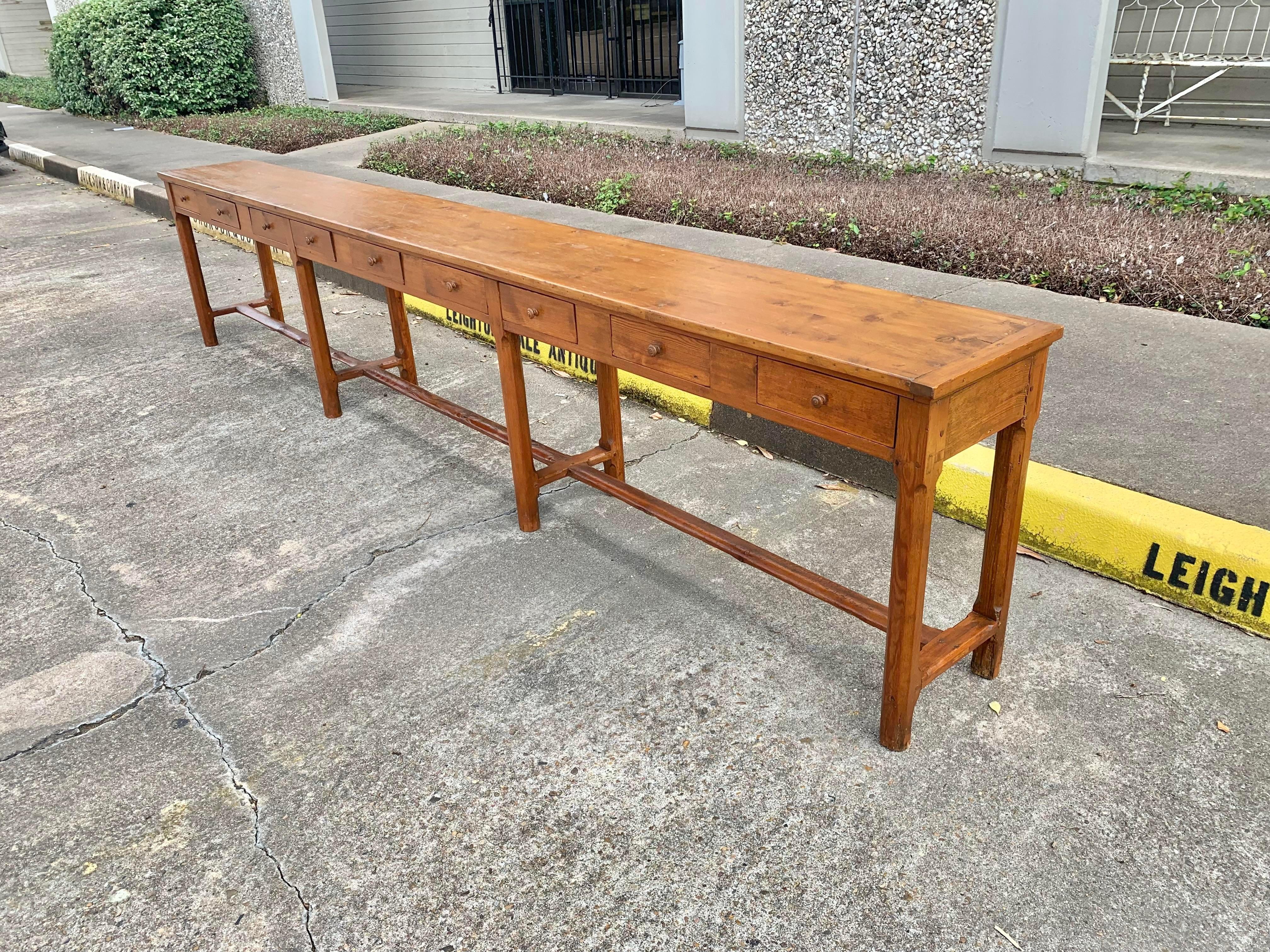 Grand in size, this 19th century French Table was once used as a desk by the novices at a convent in Northern France. Crafted from aged pine and wood pegged, the solid plank top is flanked by the traditional French bread board style ends. Each of