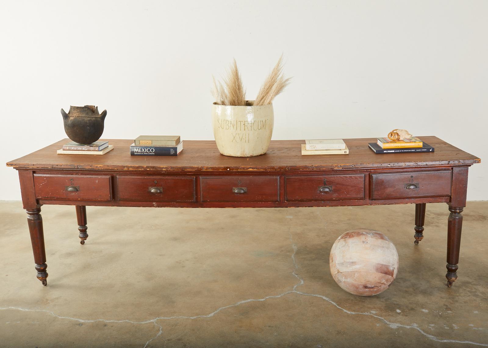 Fantastic 19th century French drapers table or store display table featuring 10 work drawers. This large table was used in cloth merchant shops for cutting long swaths or bolts of fabric. They usually had multiple drawers on each side so workers