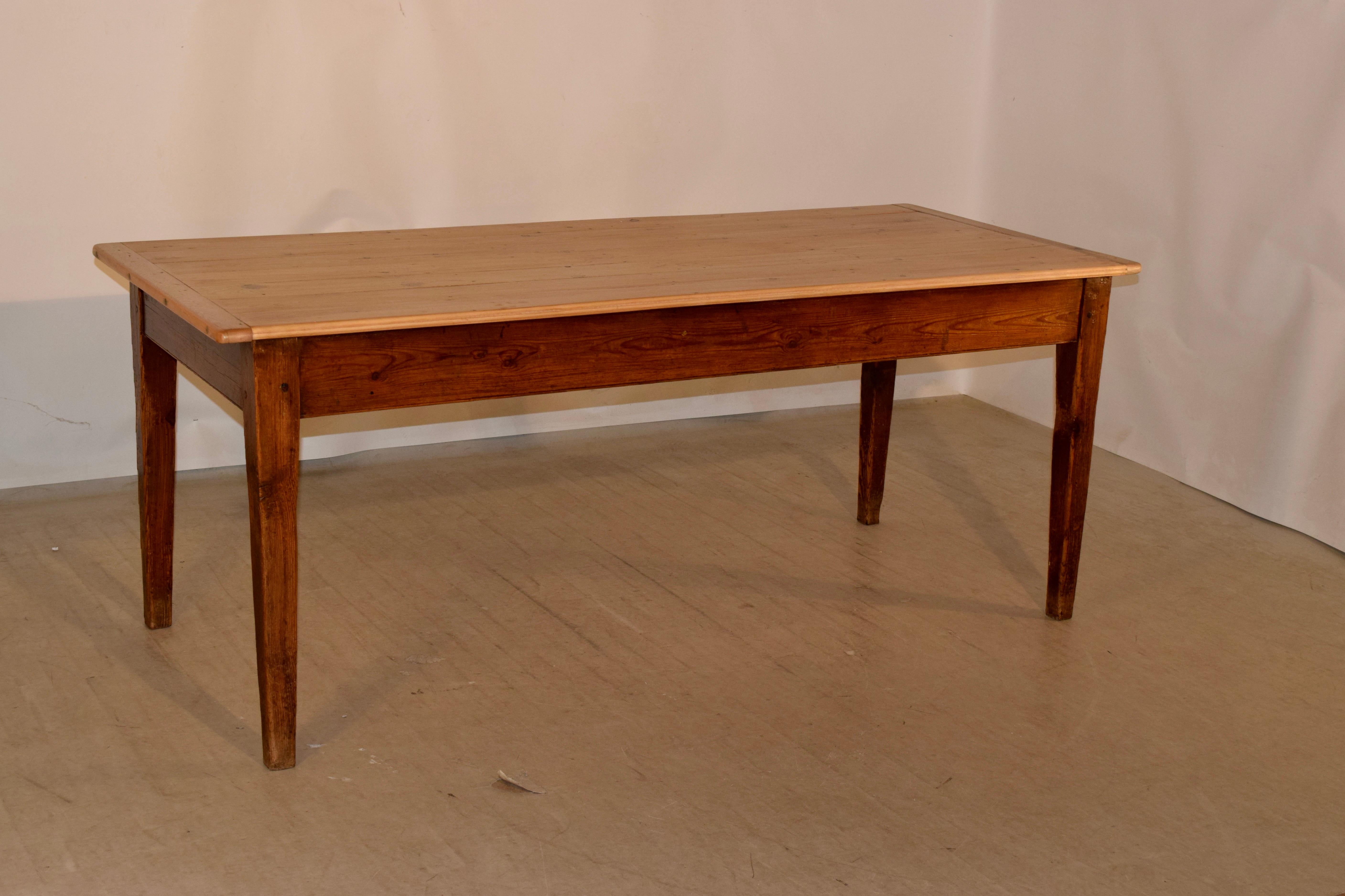 19th century French farm table with a scrubbed plank top which has banded ends, supported on a pitch pine base with tapered legs. Simple and elegant.