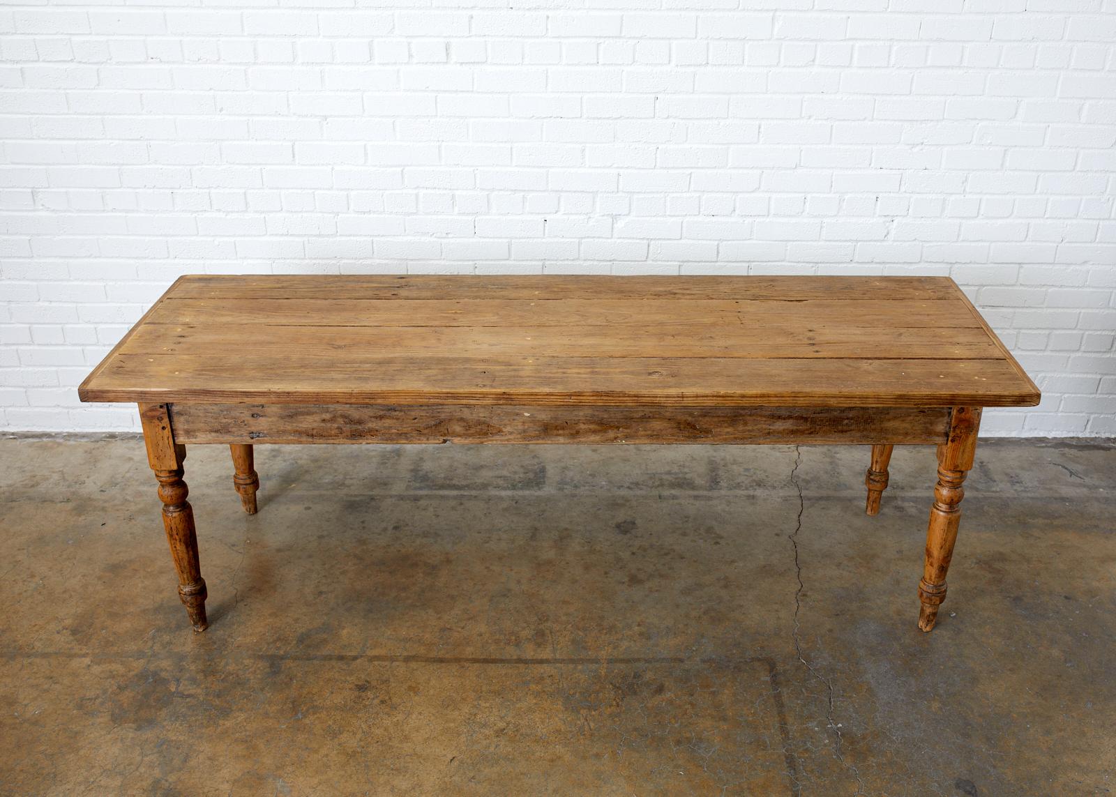 Rustic late 19th century French farmhouse harvest table or work table. Constructed from 1.5 inch thick planks of pine with breadboard ends on the top. Supported by large turned legs. The table is made with excellent joinery and craftsmanship being