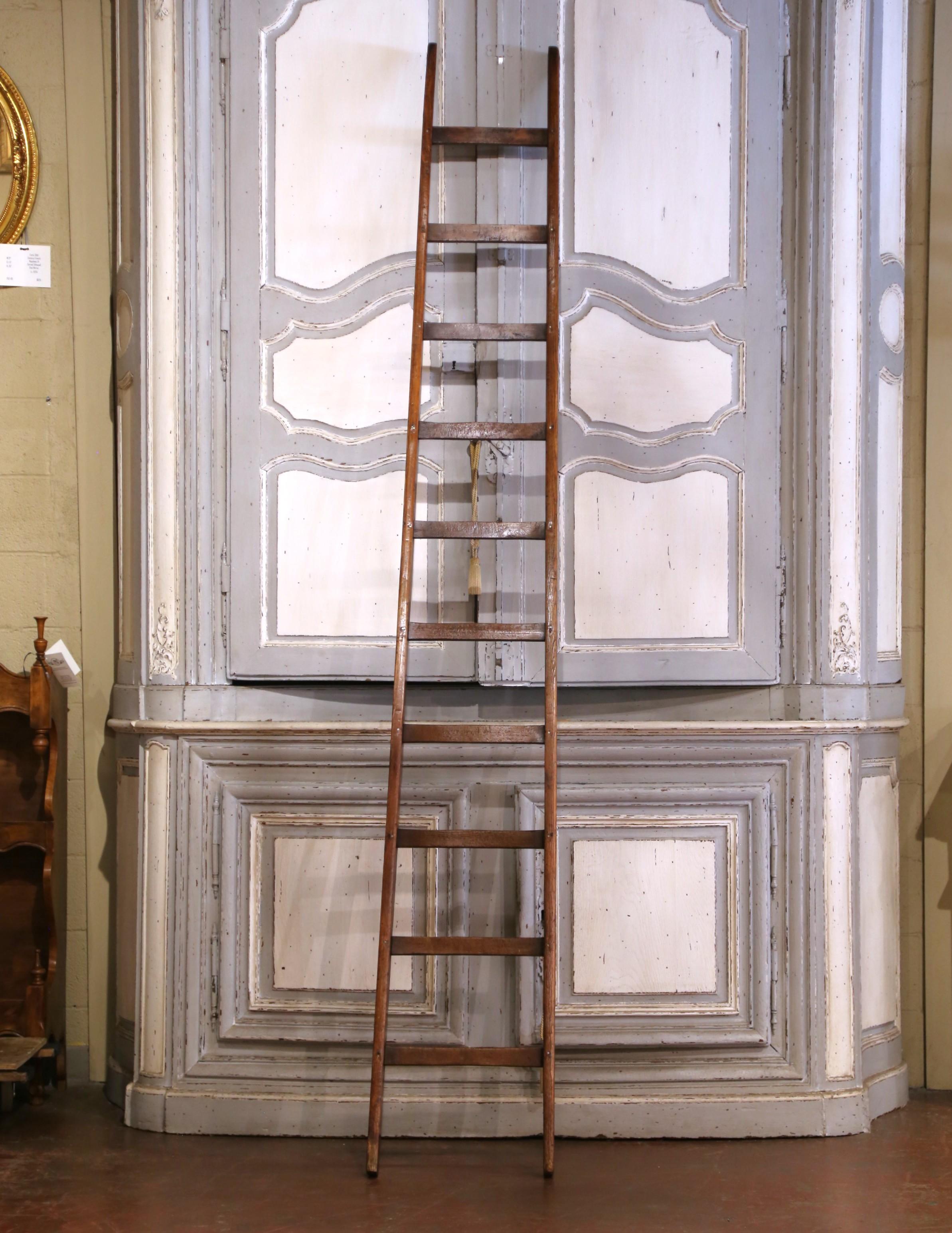 Crafted in France circa 1880, this tall and slender library ladder is made from solid pine and retains its warm, aged patina. Measuring 108 inches high, the piece features two sturdy side rails joined by ten flat, evenly spaced rungs, offering