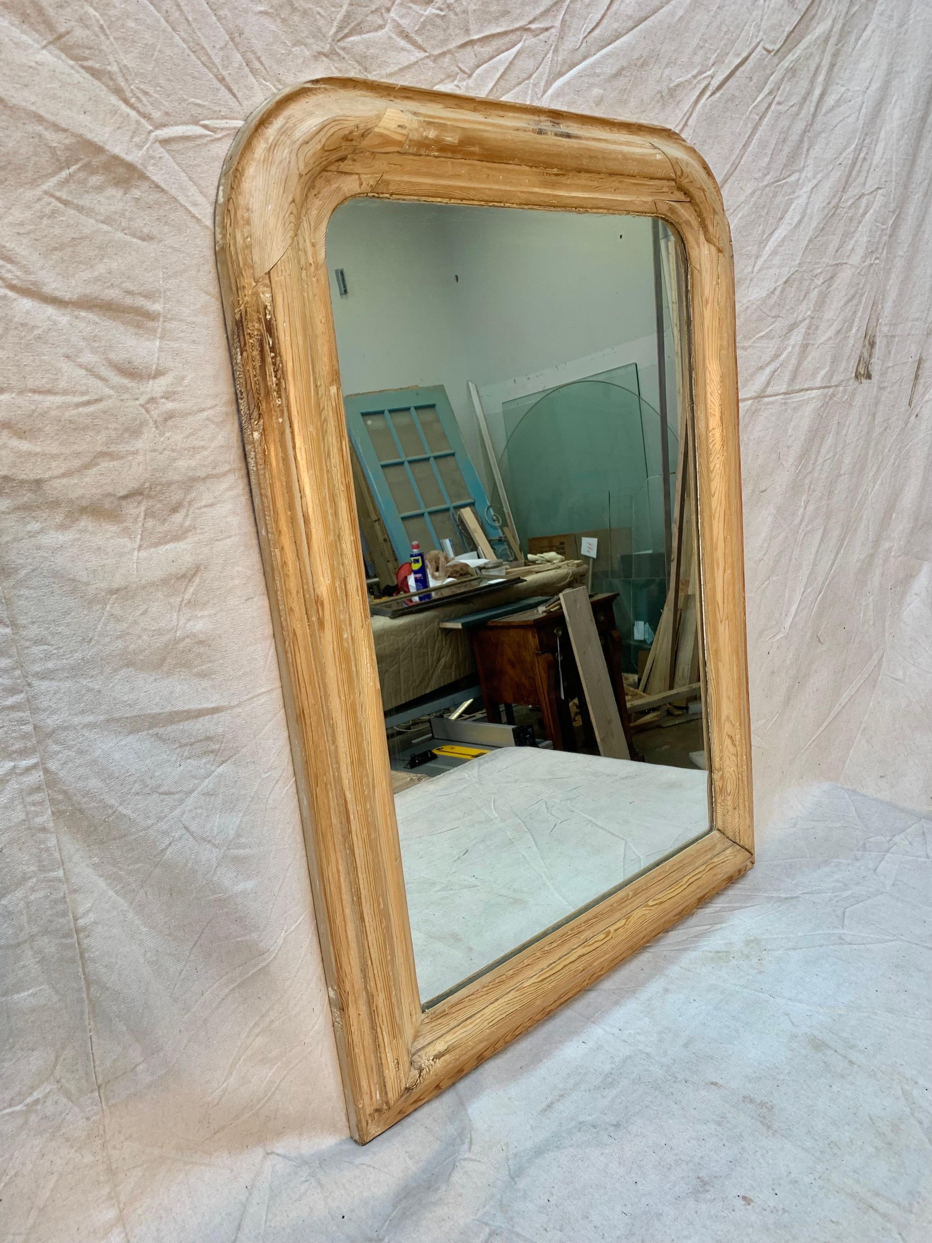 Found in the South of France this 19th Century French Louis Philippe Mirror features a beautiful  pine frame and its original mirrored glass.  Louis Phillipe mirrors are characterized by their curvaceous wide frames with rounded corners and
