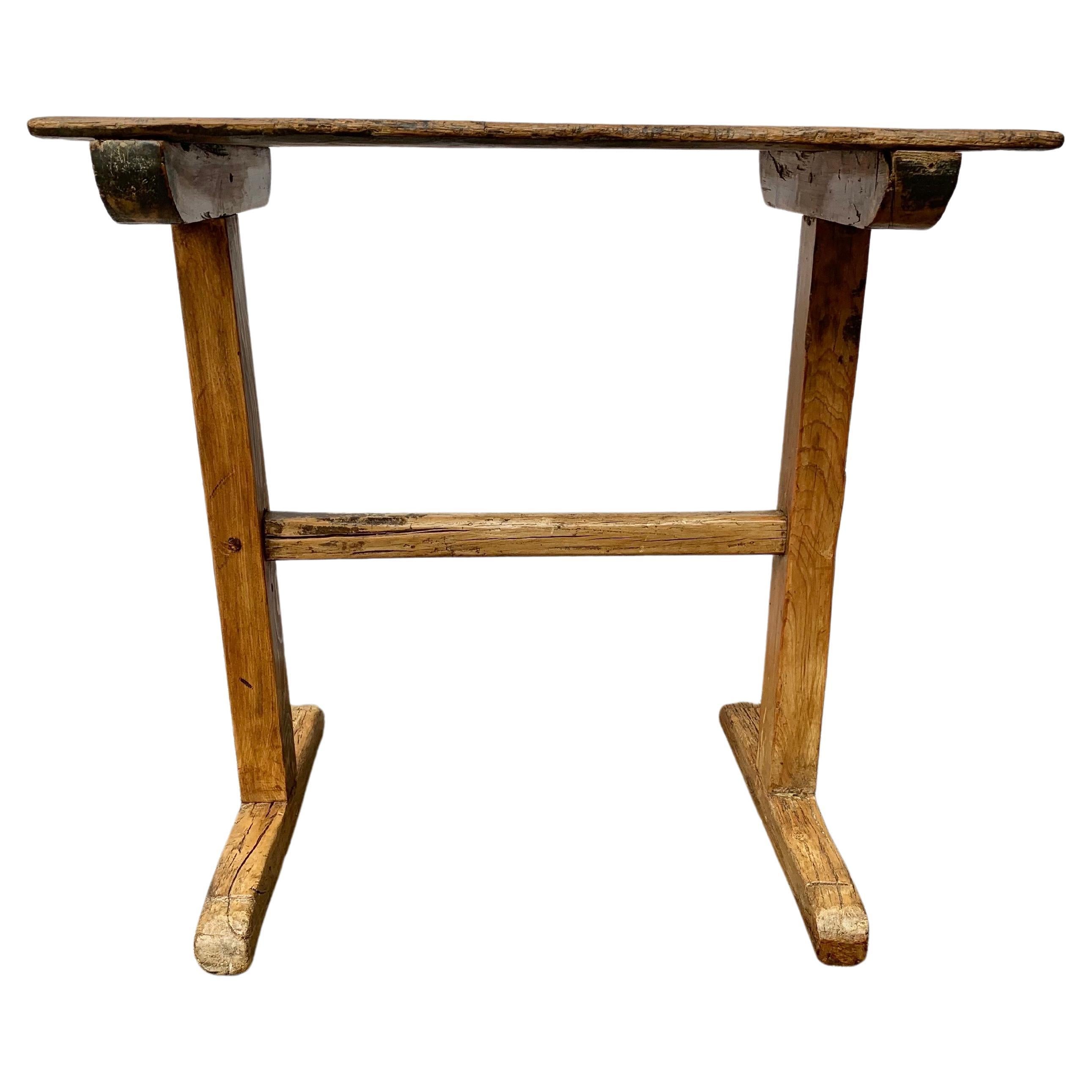 Dieser französische Beistelltisch aus dem 19. Jahrhundert, der in Südfrankreich gefunden wurde, wurde in den späten 1800er Jahren aus altem Kiefernbestand gefertigt. Das Stück hat eine rechteckige Tischplatte, die auf zwei Beinen ruht. Jedes der