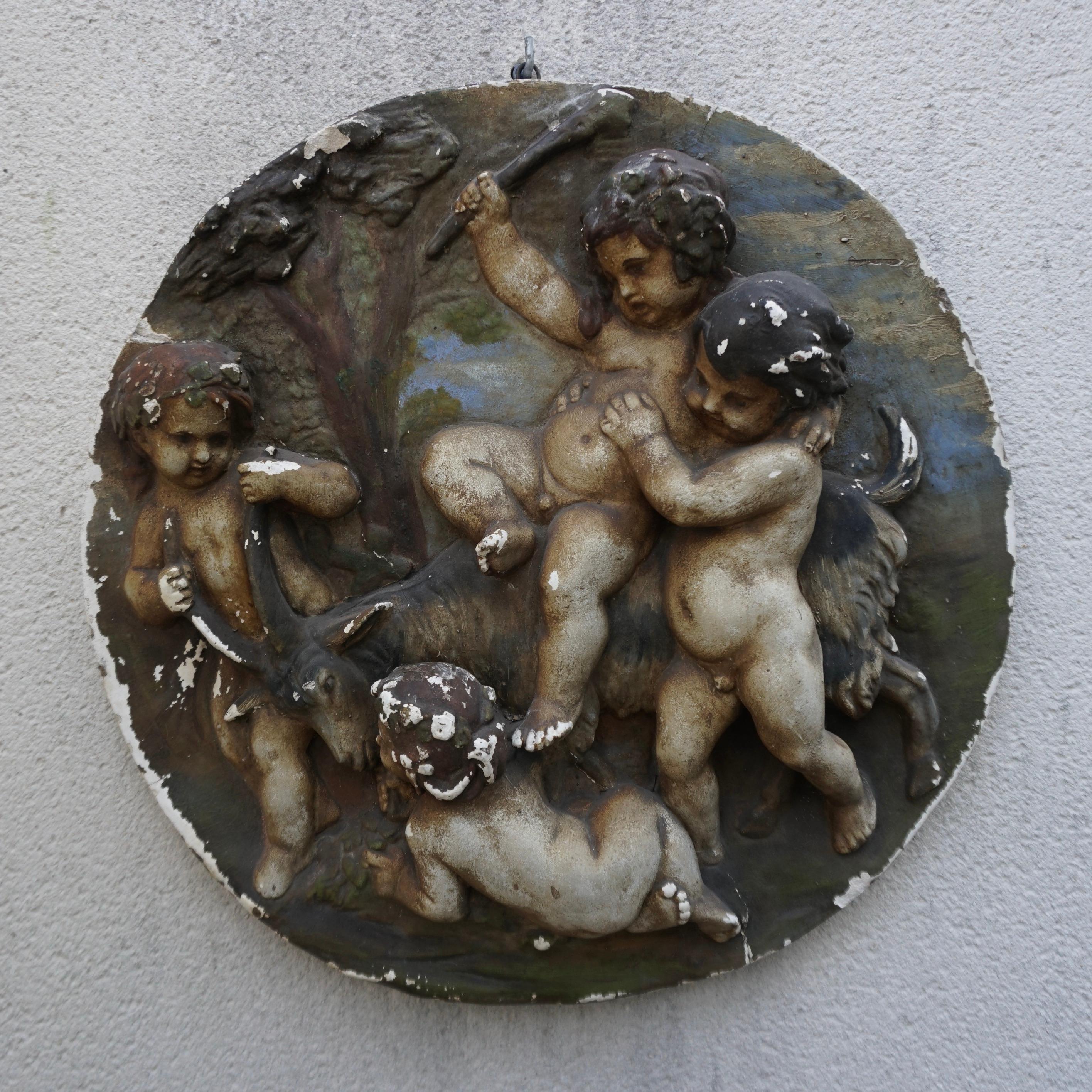 A round colorful plaster wall relief of four putti.
This beautiful religious artwork comes from an old monastery.

Diameter 20.8