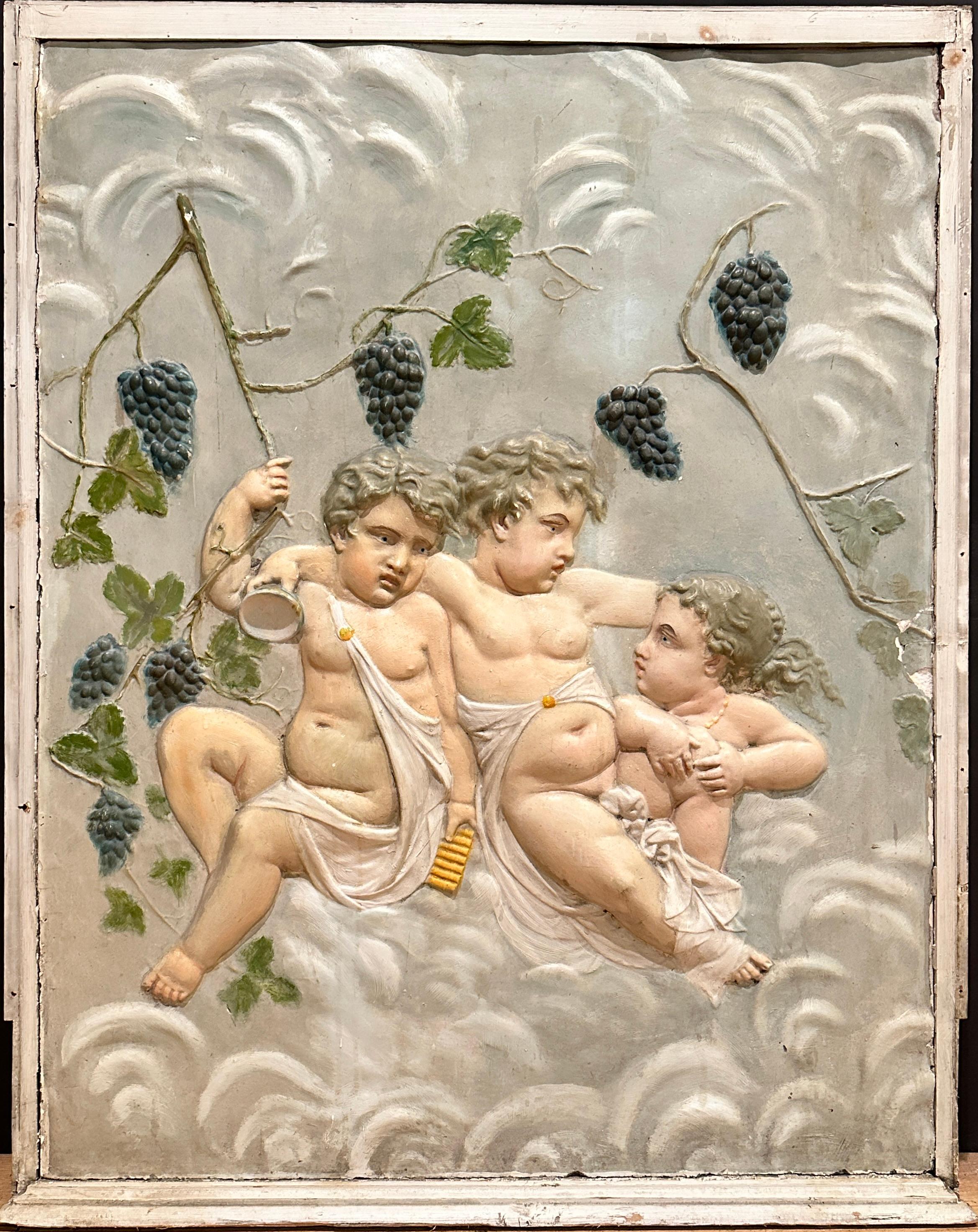 A 19th century classical and colorful plaster wall relief sculpture featuring a young Bacchus and two putti companions. Surrounded by grape vines, grapes and leaves. Sitting on cloud form and carrying a wine cup and Pan flute.
Perfect for a wine