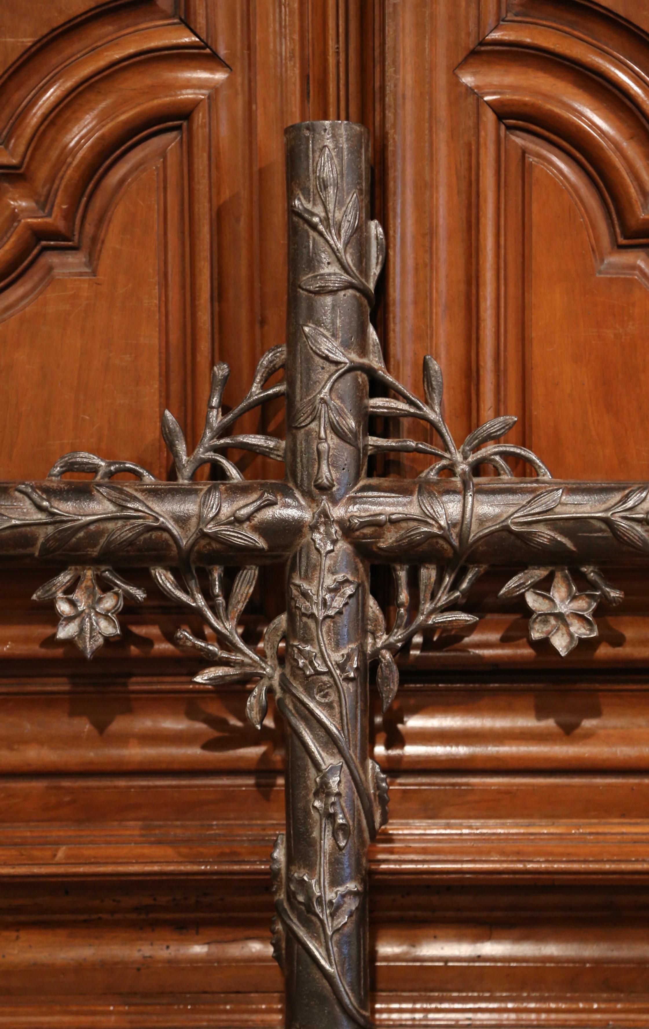 This beautiful, antique cross was crafted in France, circa 1860. The large and round iron piece is decorated with floral and leaf motifs in high relief all-over the cross. The Classic religious sculpture has a rich polished patinated finish