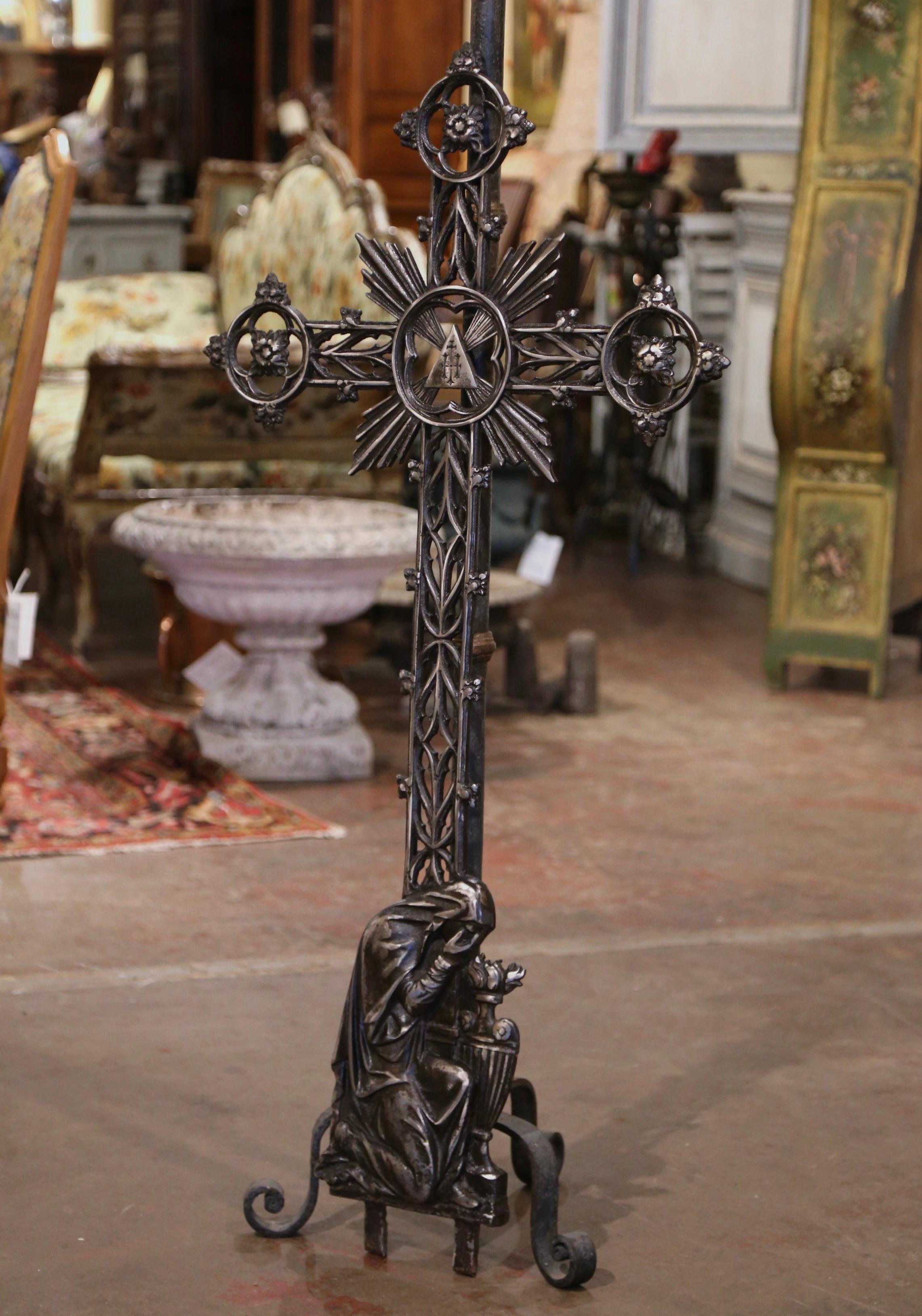 This beautiful antique cross was crafted in France, circa 1870. The large iron religious item decorated with scroll and floral motifs is embellished with the Holy Trinity at the center, surrounded by beautifully crafted sun rays; It represents the