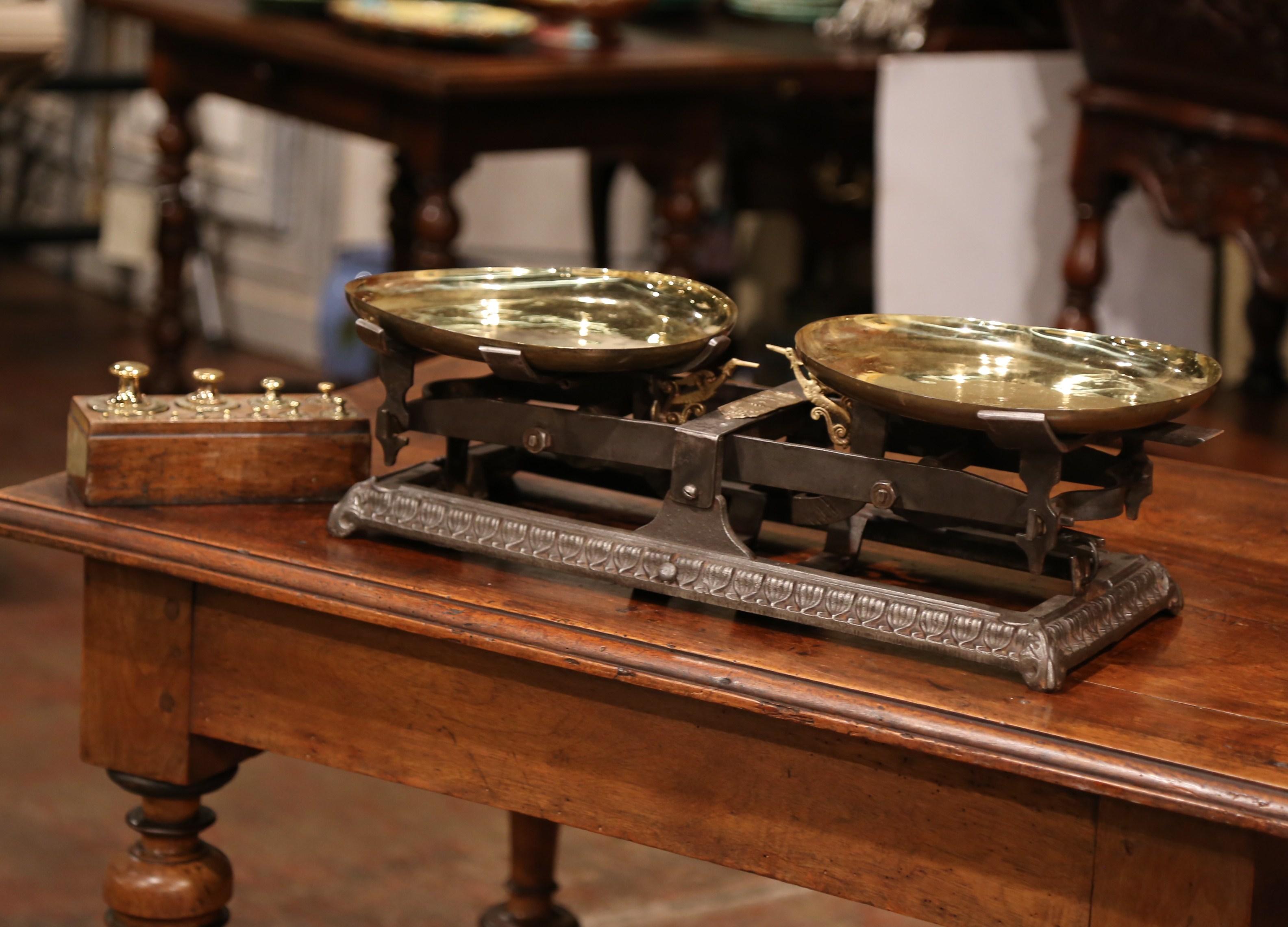 Add some European flair to your kitchen counter with this elegant antique scale. Crafted in France circa 1870 and rectangular in shape, the iron scale features the original pair of polished brass plateaus. The functional measure devise is signed on