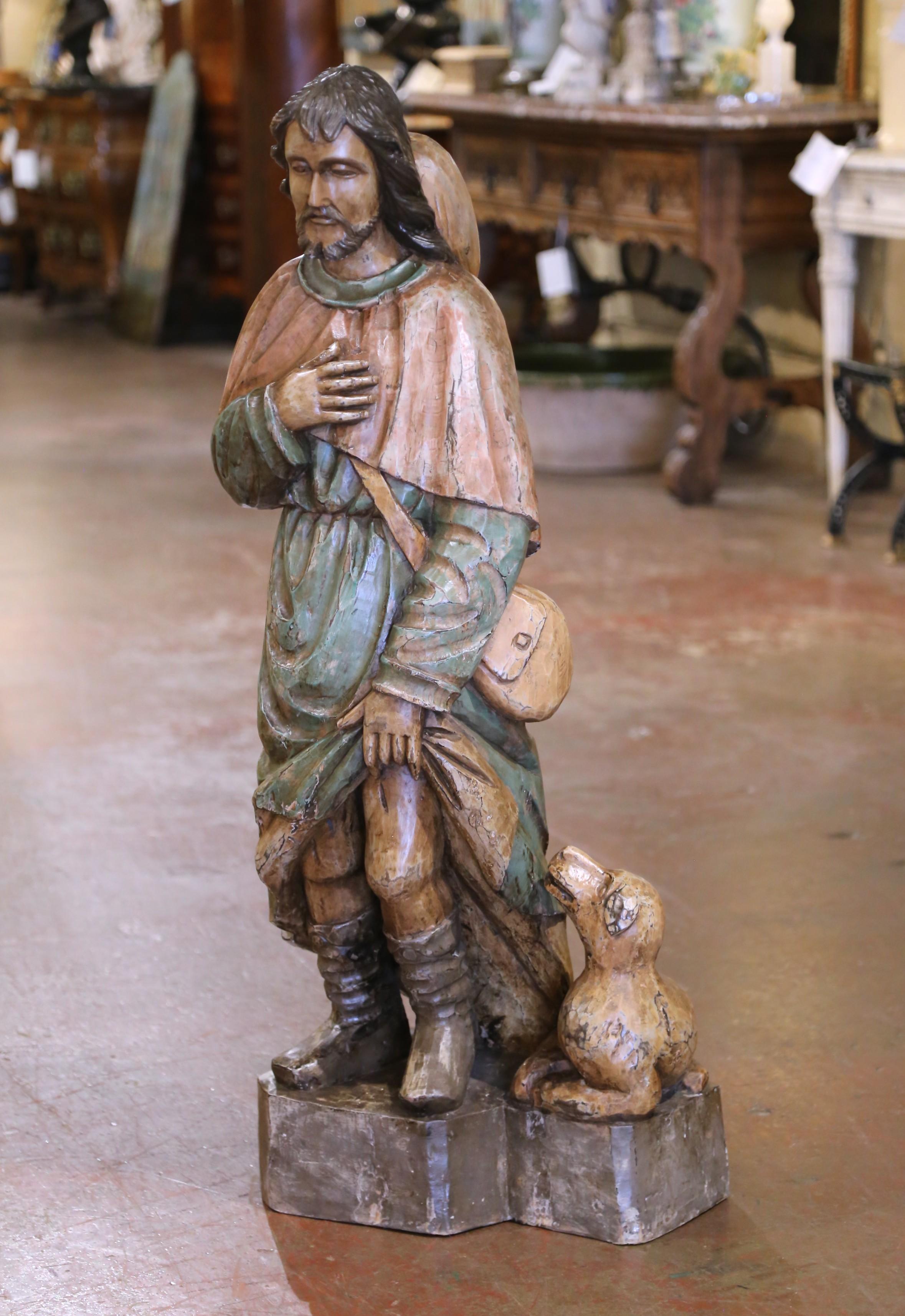 Honra el legado de un querido santo francés con esta expresiva escultura antigua de madera policromada de San Roque.
Tallada en Francia hacia 1870 y con una impresionante altura de metro y medio, la figura conserva su acabado pintado original. San