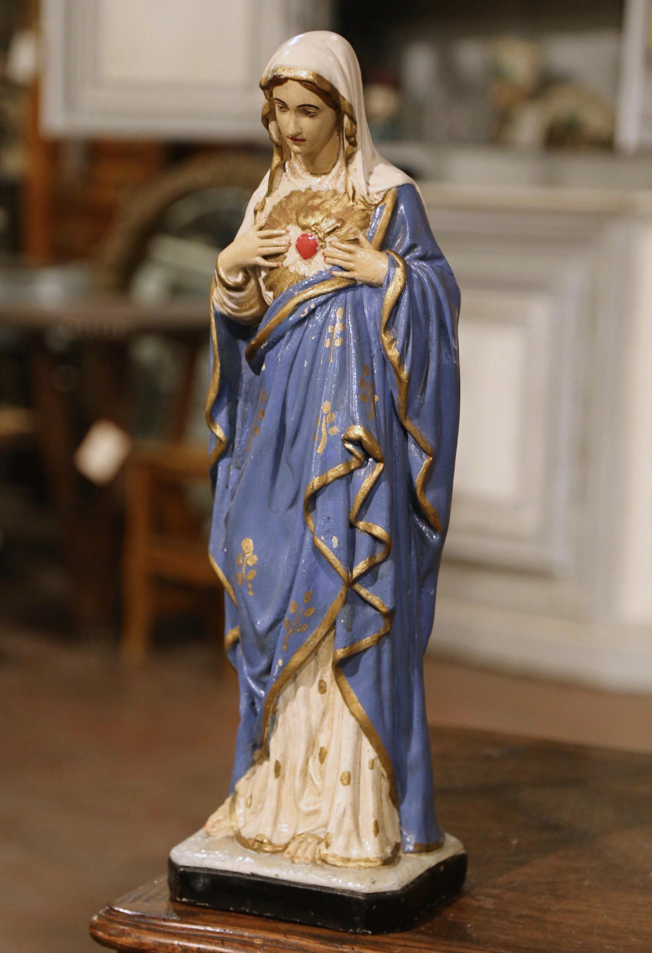 This beautiful and colorful antique Virgin Mary statue was hand carved in France, circa 1890. Built of terracotta, the sculpture depicts our Mother standing and showing her Immaculate Sacred Heart. The religious statue is in excellent condition with