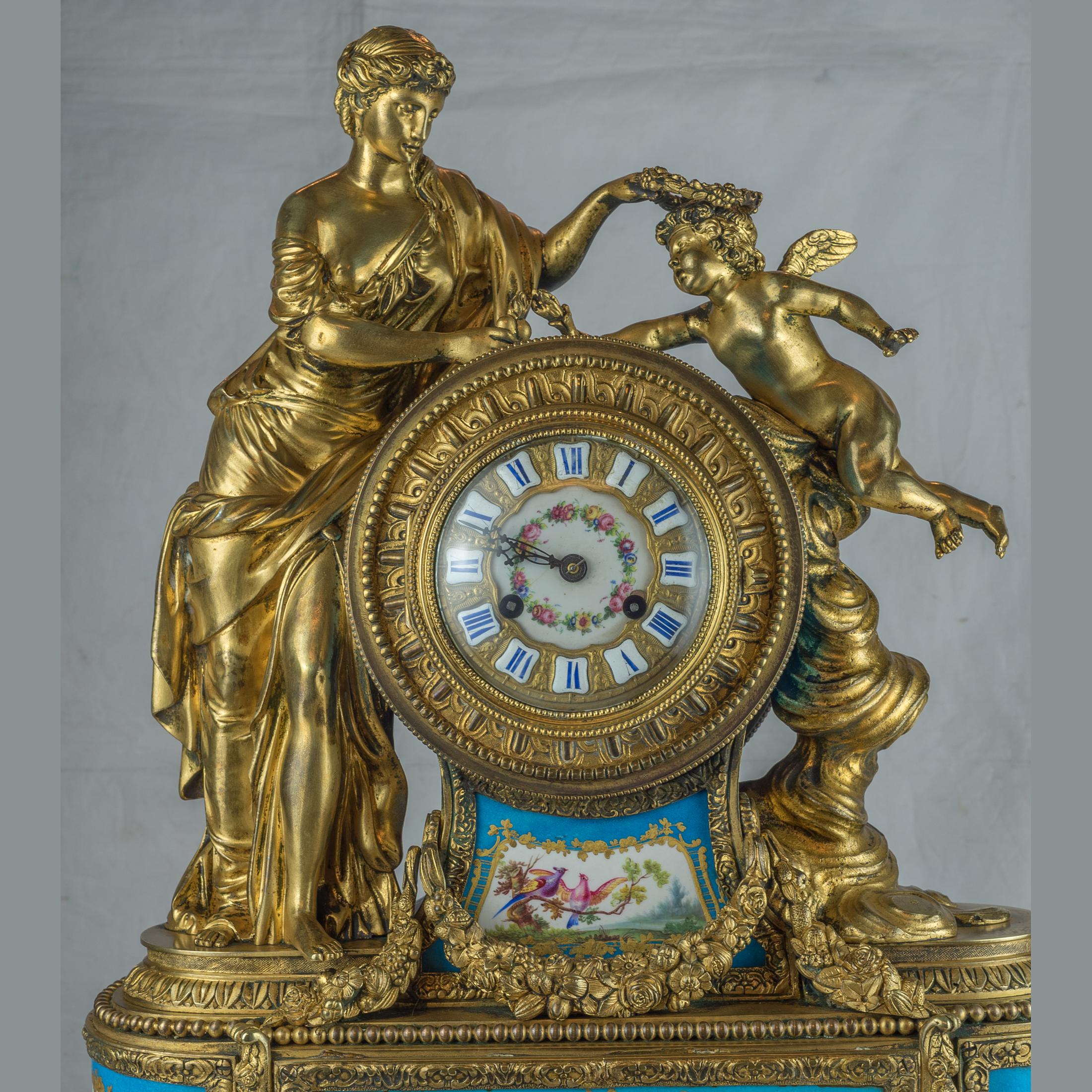 A fine quality gilt bronze and porcelain figural mantel clock. The figure of a maiden placing a garland of flowers over the cherub’s head. 

Origin: French
Date: circa 1880
Dimension: 23 in x 18 in.