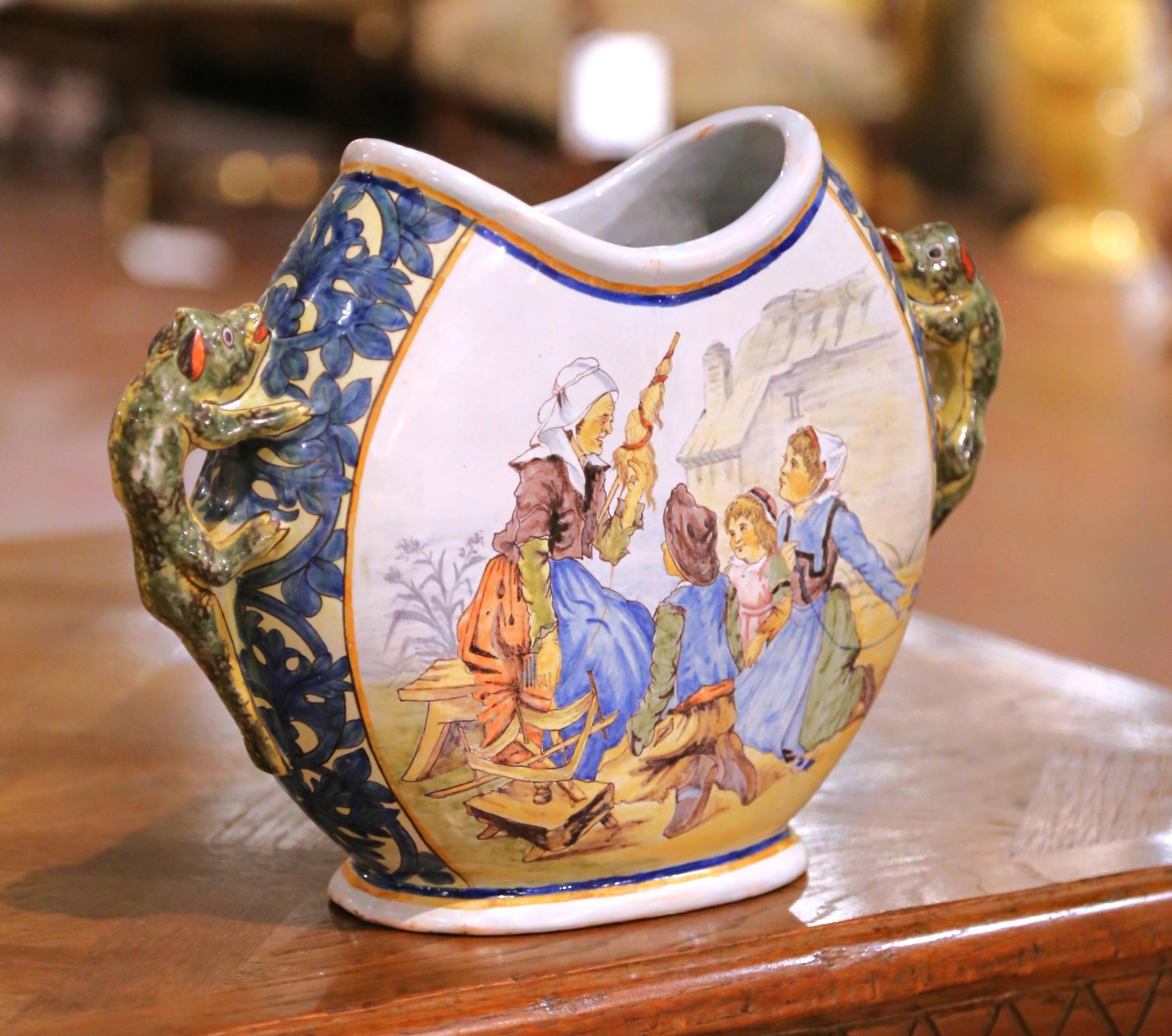 Rehaussez une étagère, une console ou une armoire avec ce charmant vase ancien en faïence de Quimper, fabriqué en Bretagne vers 1895 à la célèbre époque de Porquier-Beau. De profil lunaire et munie de deux poignées sculptées en forme de lézard, la