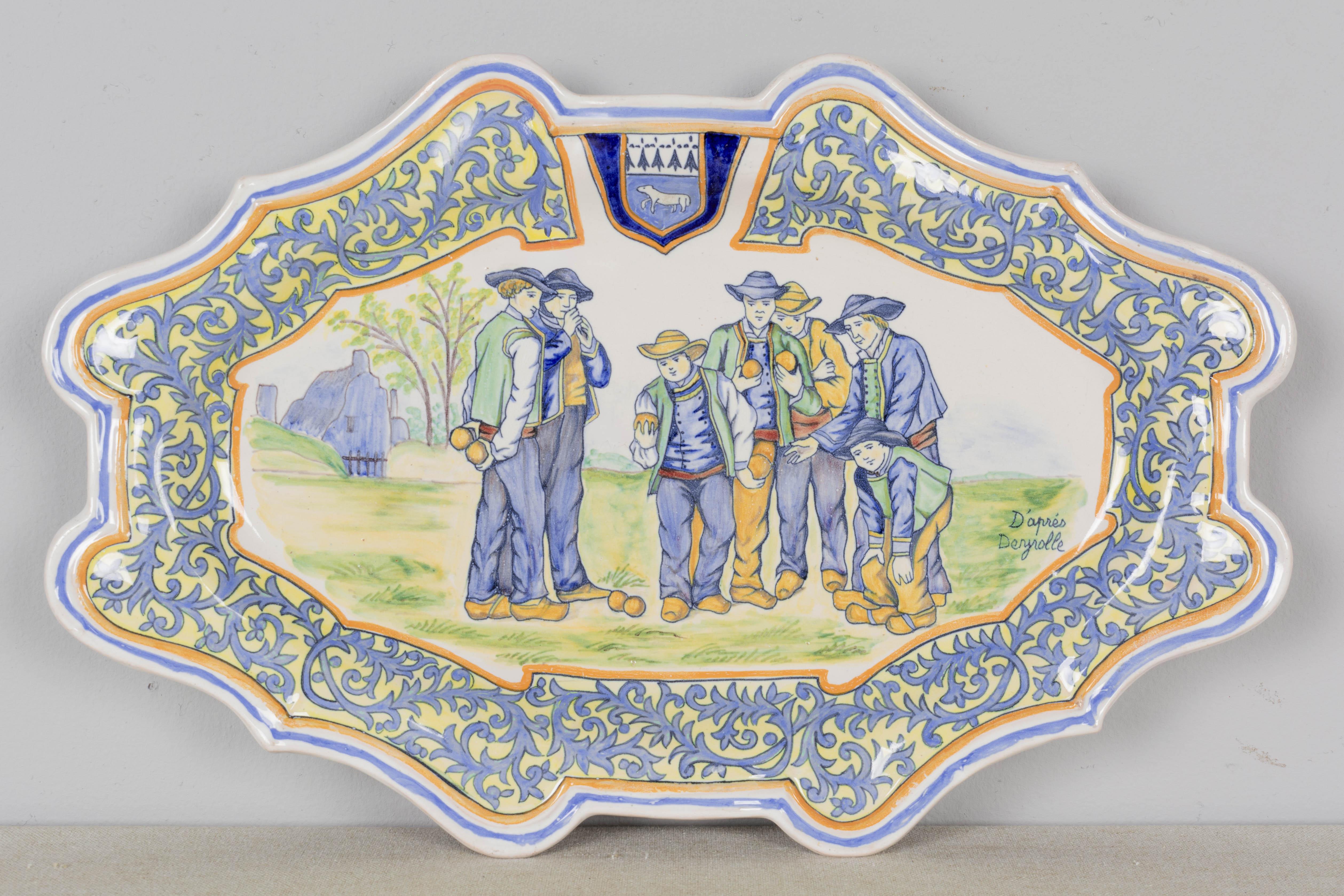 Fuente ovalada oblonga decorativa de loza Porquier Beau Quimper francesa del siglo XIX, pintada a mano con hombres jugando a la petanca. D'apres Deyrolle. Borde ancho foliado azul claro con escudo de Quimper.  Marca en el verso: PB Quimper. Hacia