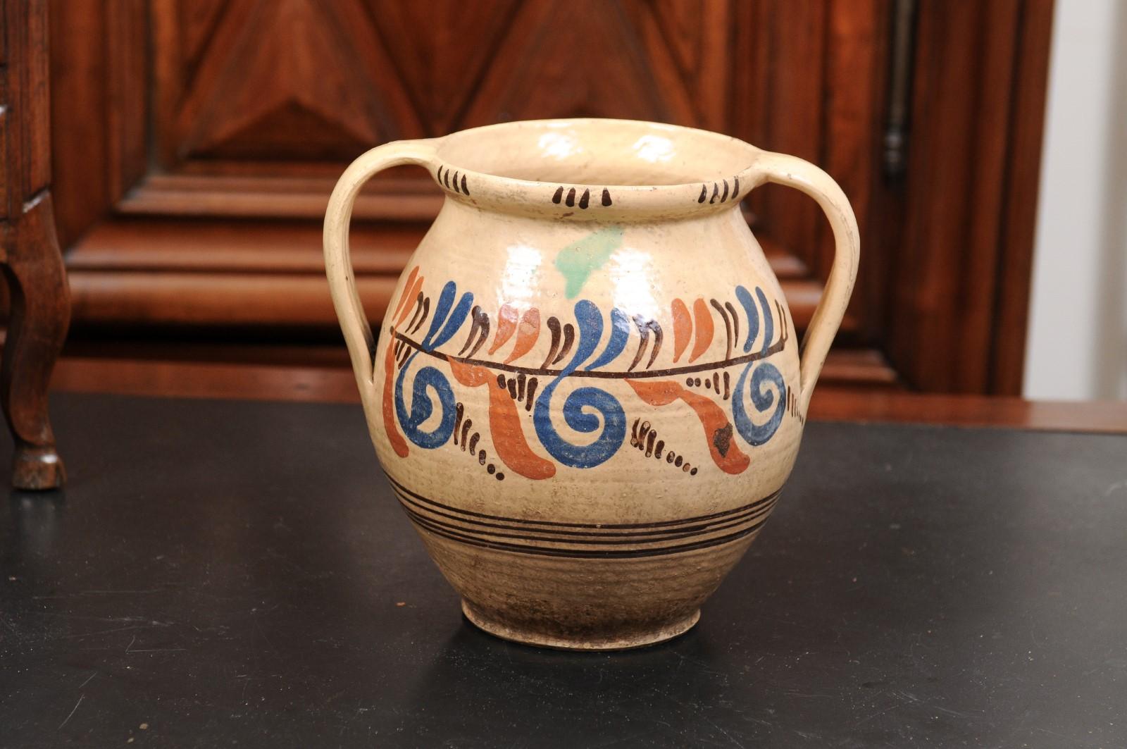 A French pottery confit pot from the 19th century, with cream glaze and blue and brown scrolling motifs. Created in France during the 19th century, this pot à confit features a generous body covered with a cream ground accented with blue, brown and