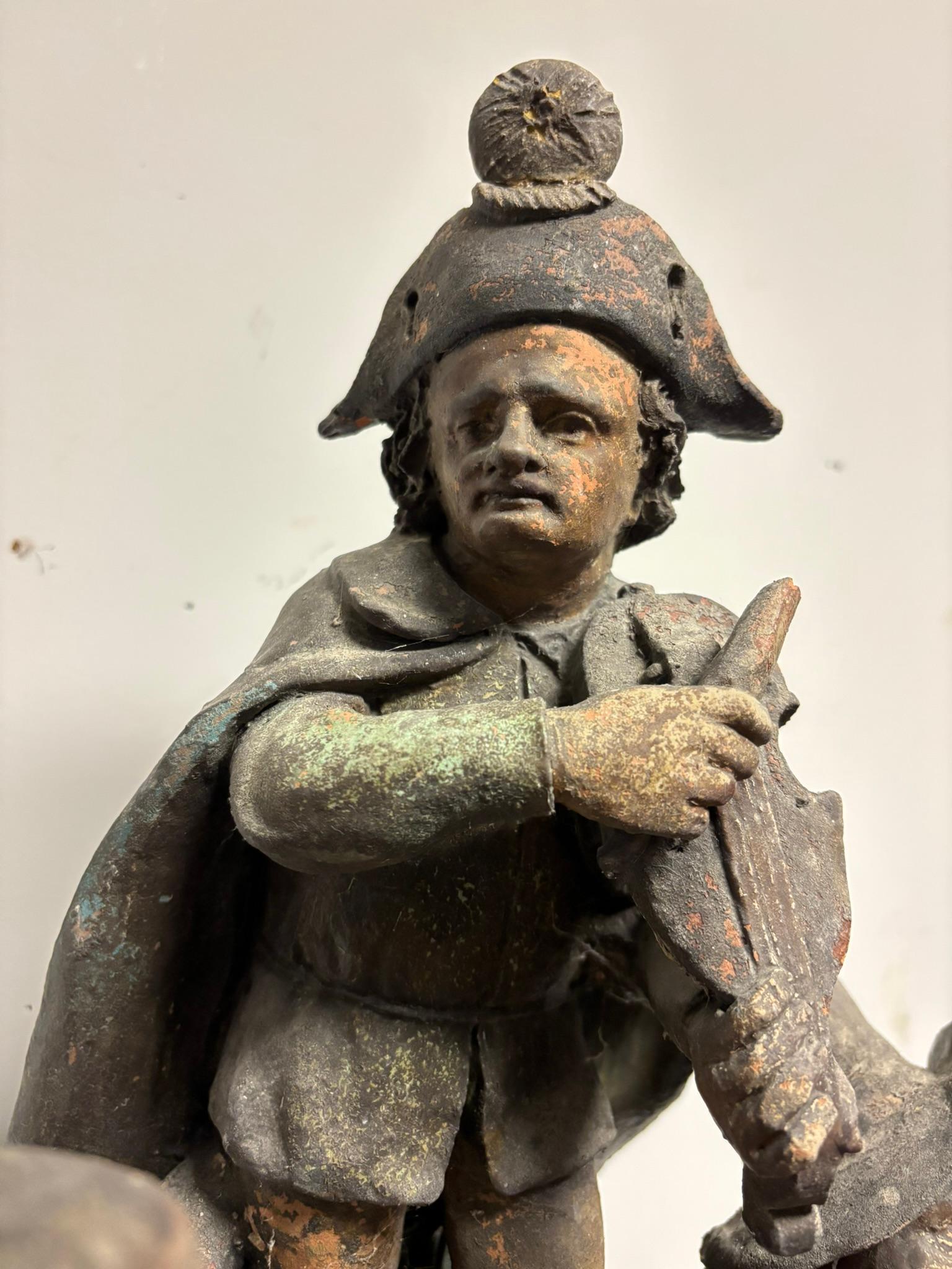 Französische Keramik aus dem 19. Jahrhundert mit drei Musikern und zwei Tänzerinnen. Diese sehr ungewöhnliche Gruppe zeigt eine Figur von Napoleon oder vielleicht Richard Wagner, die einen Hut und einen Umhang mit zwei Hörnern trägt und auf einem