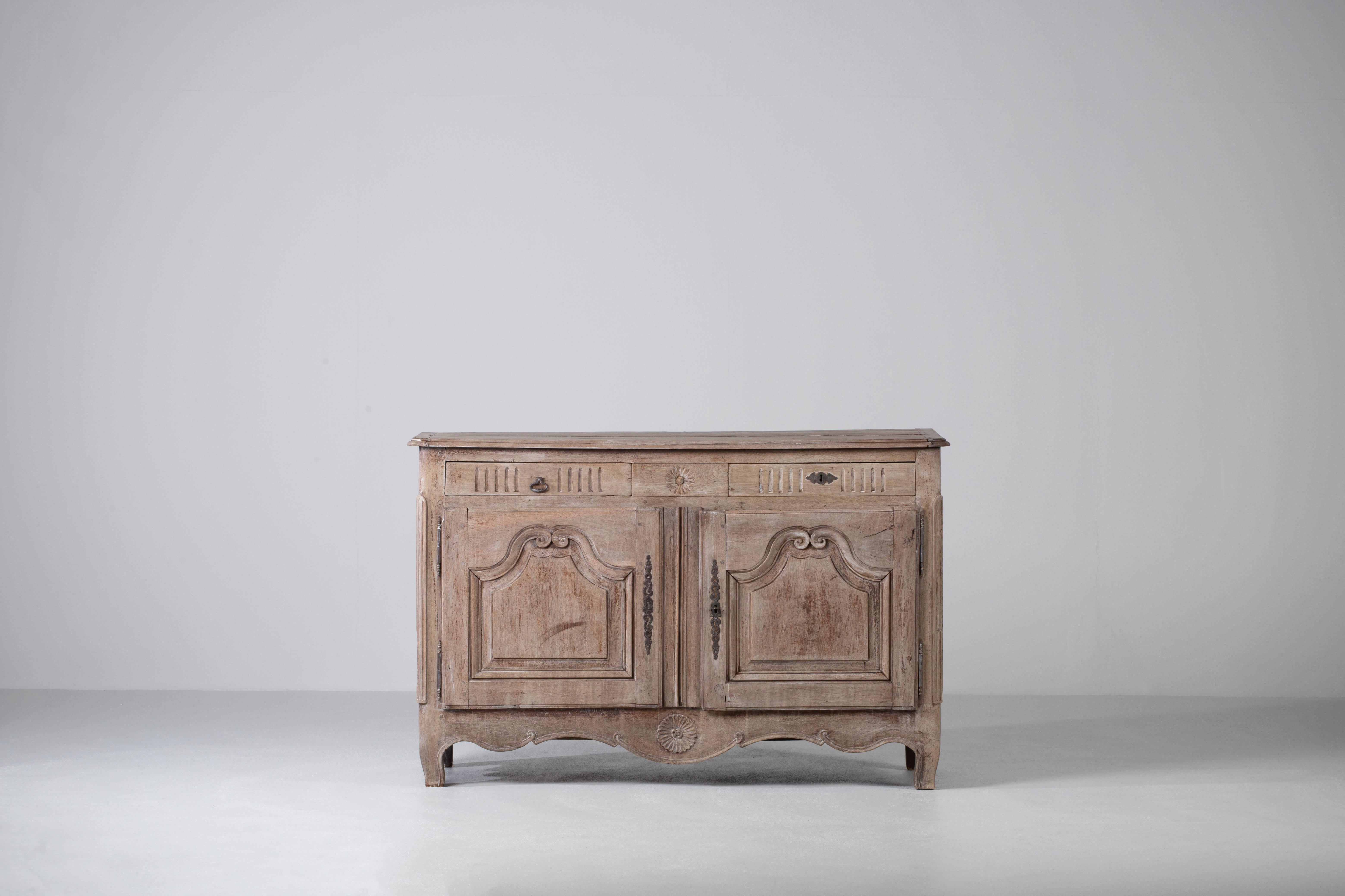 A two door and drawer provencal cabinet from France, circa 1890. Representing the casual yet refined aesthetic of the French countryside, finished in a contemporary bright finish, enhancing the natural textured figure of the wood and subtle carved