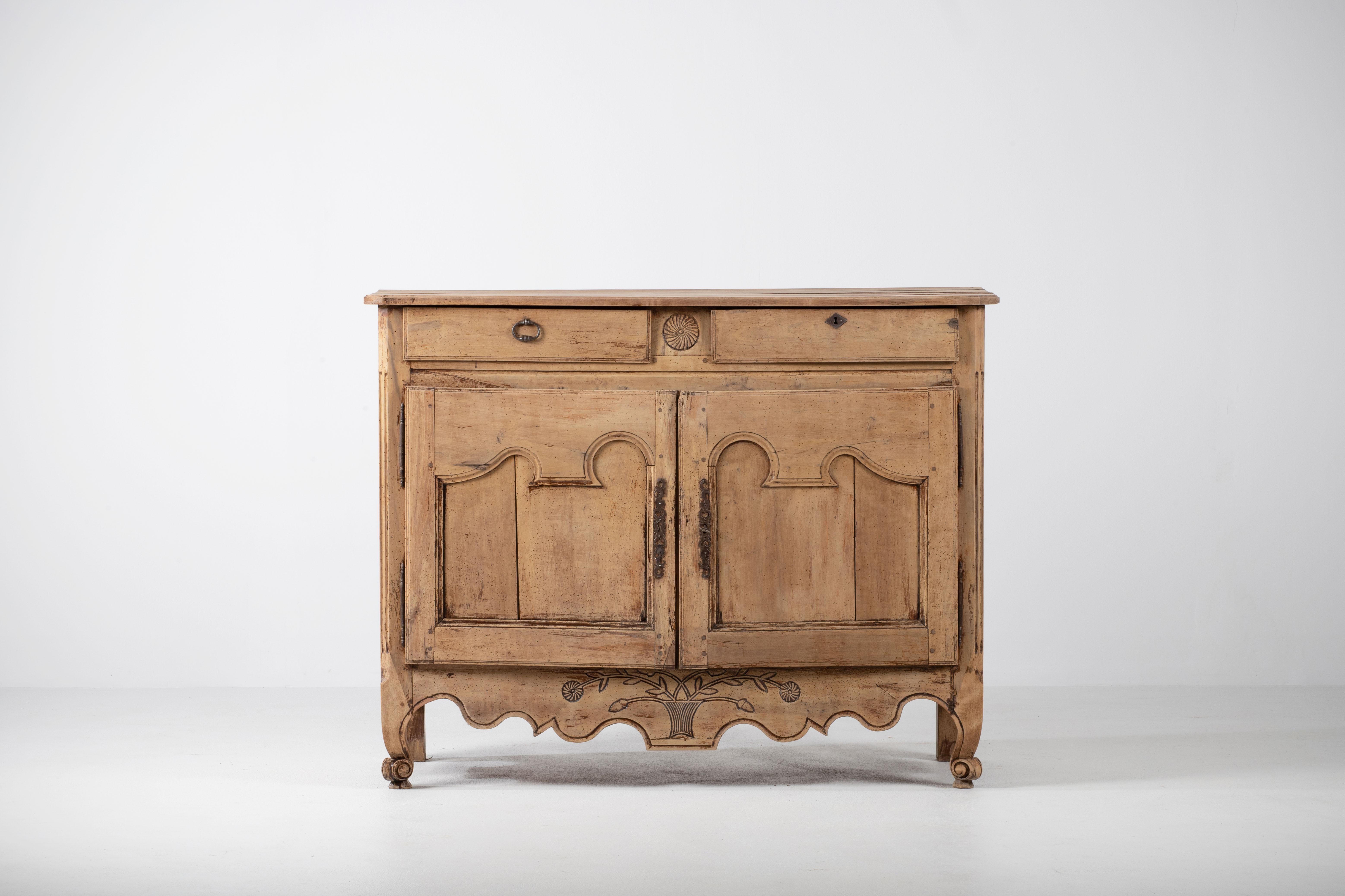 A two door and drawer provencal cabinet from France, circa 1890. Representing the casual yet refined aesthetic of the French countryside, patinated, enhancing the natural textured figure of the wood and subtle carved ornament. 
A testament to the