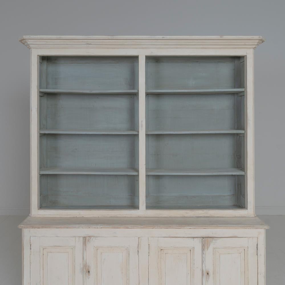 A French bibliotheque from the 19th century with a beautiful patina. This four-door bookcase is wearing time-worn old paint and has two keys. This is a great piece that comes in two parts (upper bookcase and lower buffet) with plenty of storage