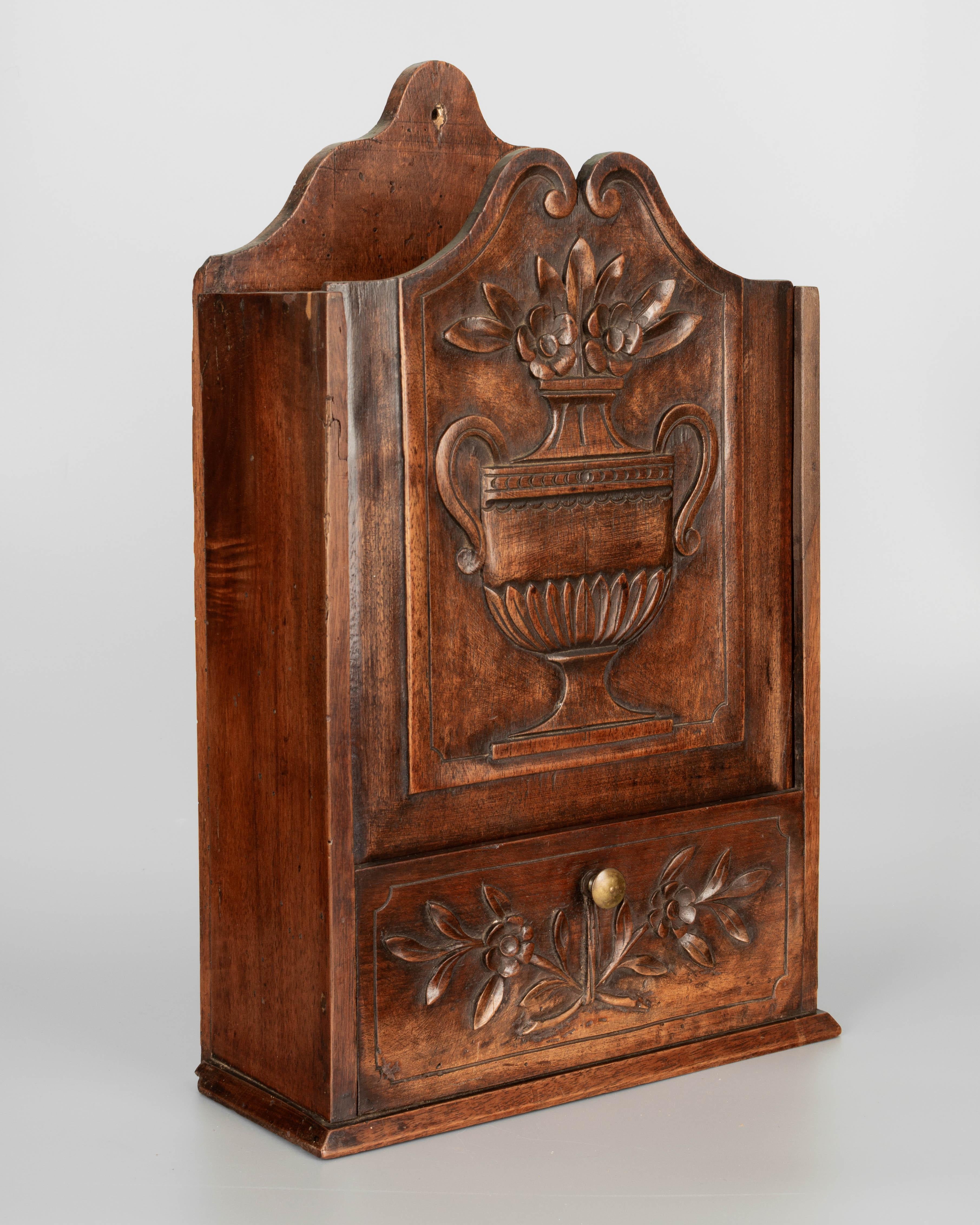A 19th century French Provençal fariniere, or decorative box made of walnut with fine hand-carved decoration of a large flower urn. Waxed patina. This beautifully crafted household item was commonly given as a wedding gift and would be displayed on