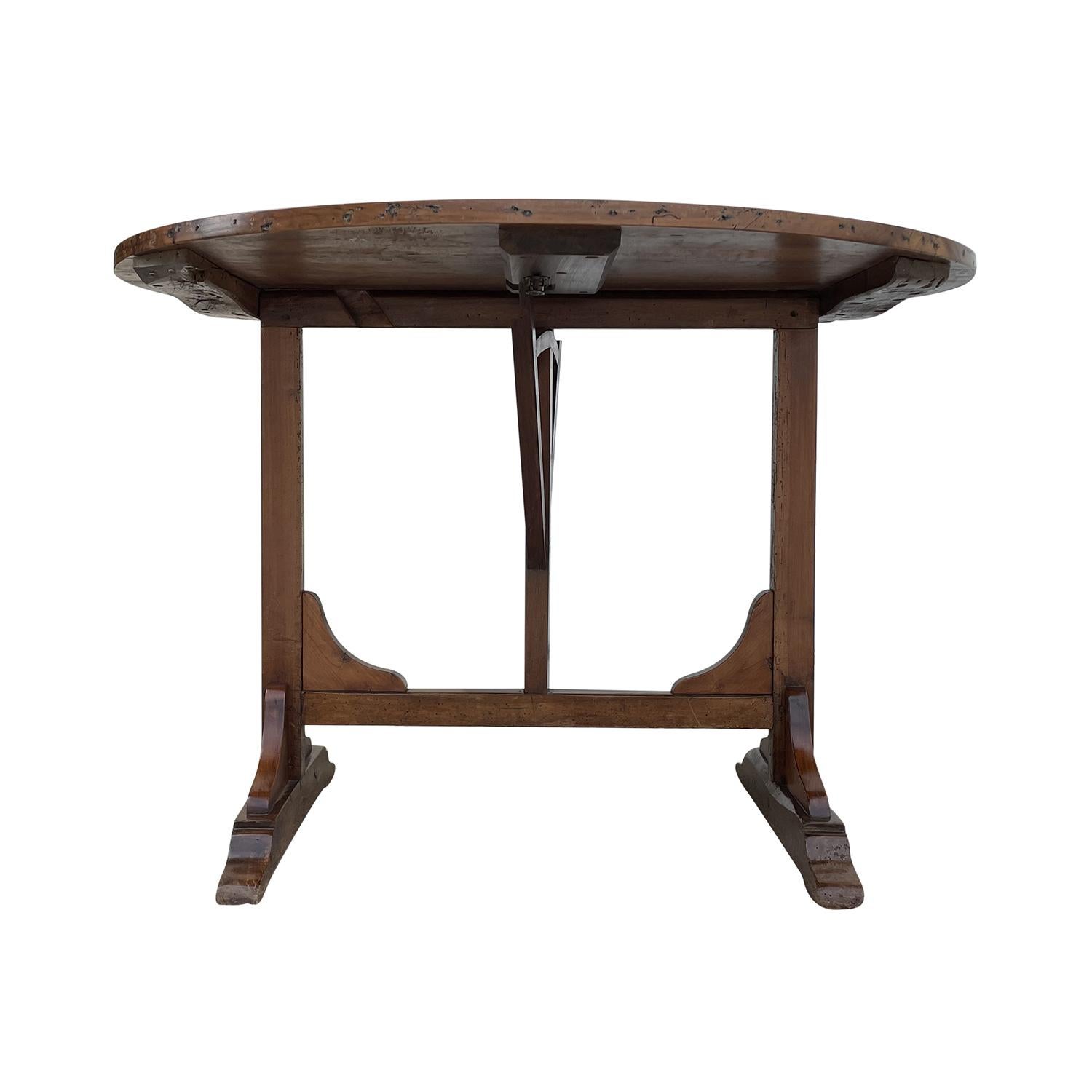 A small, antique round French Provencal folding wine, center table made of hand crafted Walnut, in good condition. The Vigneron tables are used in France as occasional tables in wine cellars. Wear consistent with age and use. Circa 1880, France.