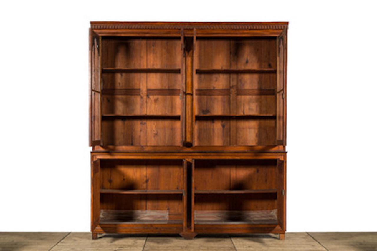 A stunning large 19th century French 4-door Bookcase or cabinet in pitch pine, featuring 4 glazed shaped doors enclosing adjustable shelves with cupboards below, standing on block feet. Beautiful patina and colour. Original panelled back, working